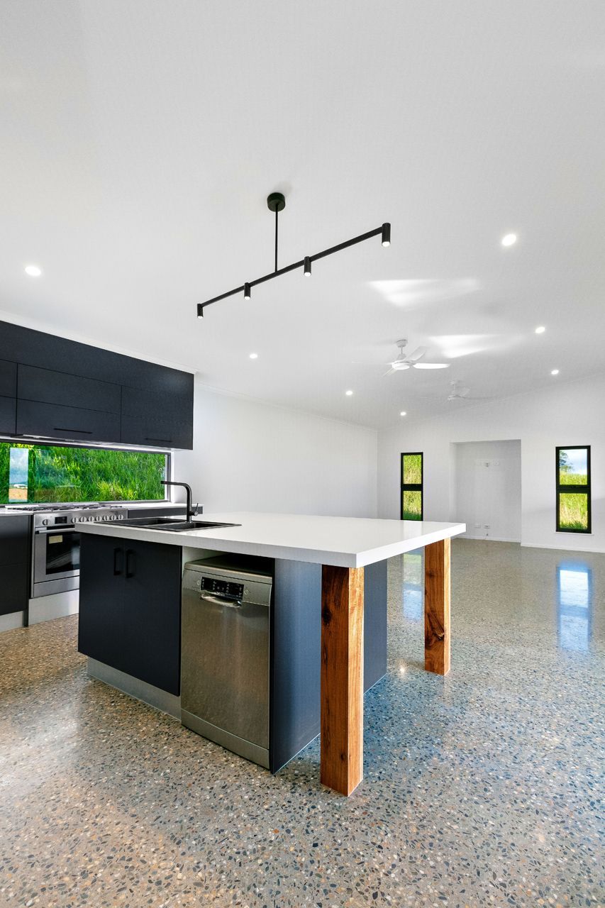 Modern Kitchen With a Dark Blue Island, White Countertop — Ashlee Jones Homes in Gordonvale, QLD