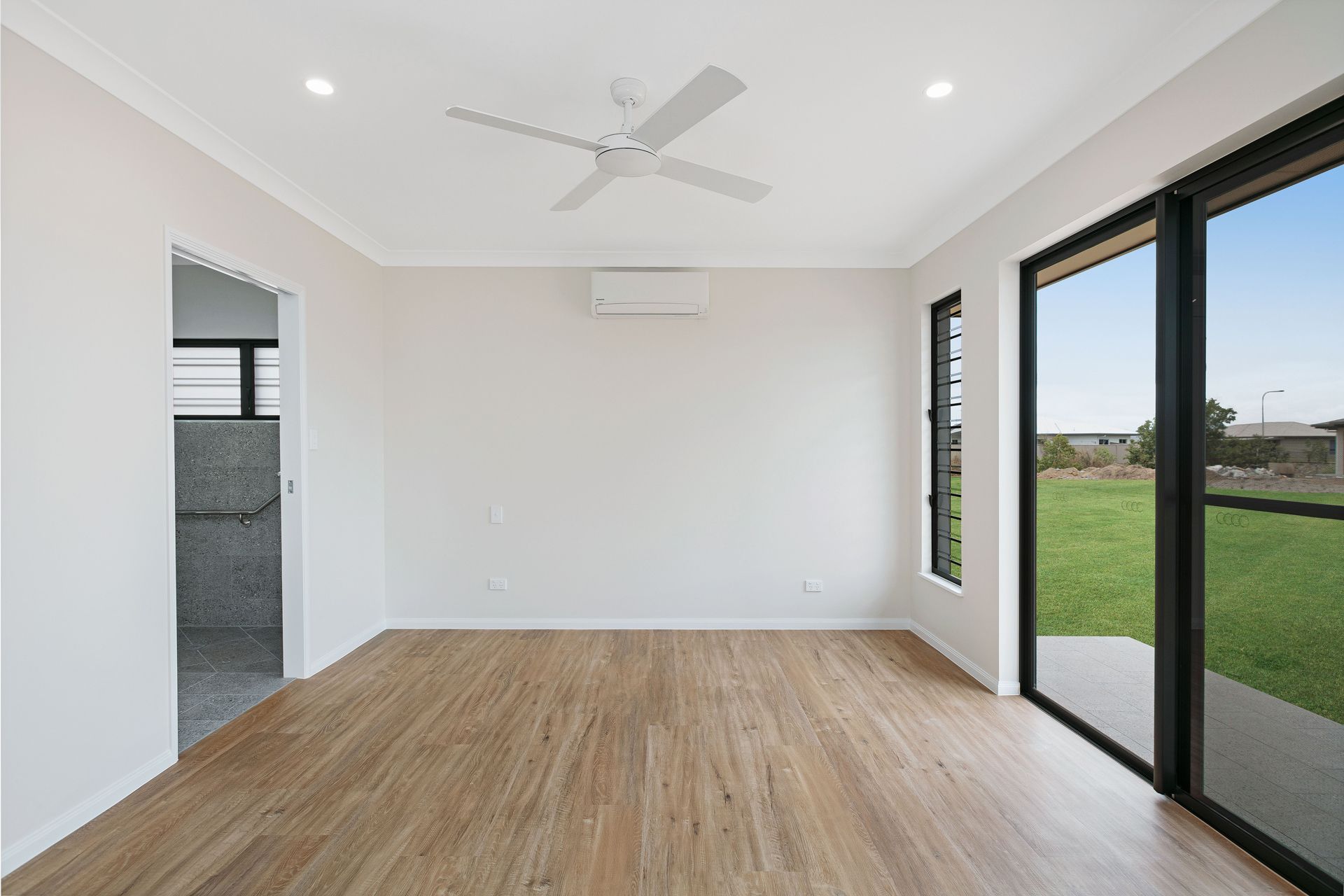 A Bright, Empty Room With Light Wood-look Flooring — Ashlee Jones Homes in Gordonvale, QLD