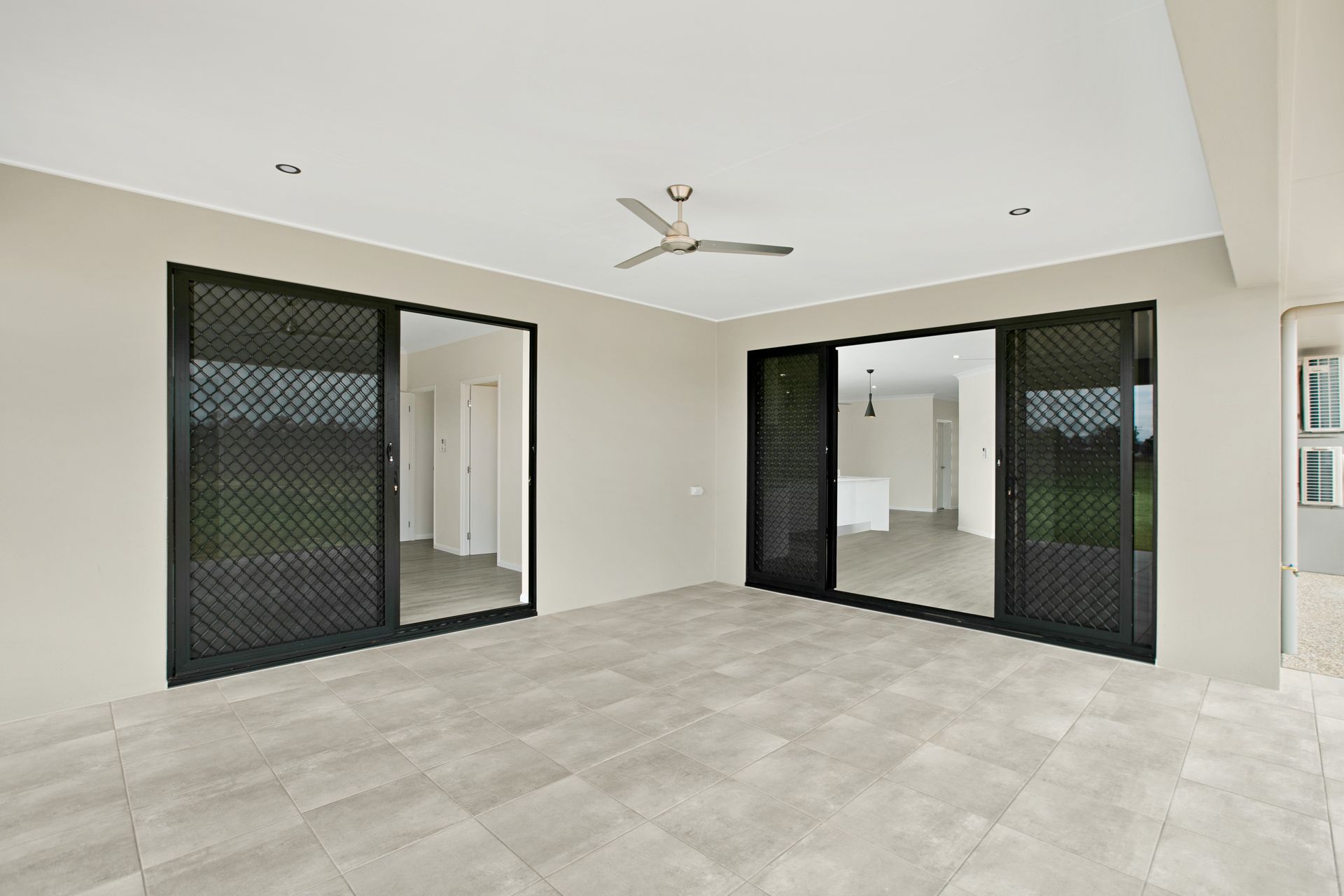 A Modern Covered Patio With Grey Tiled Floors — Ashlee Jones Homes in Gordonvale, QLD