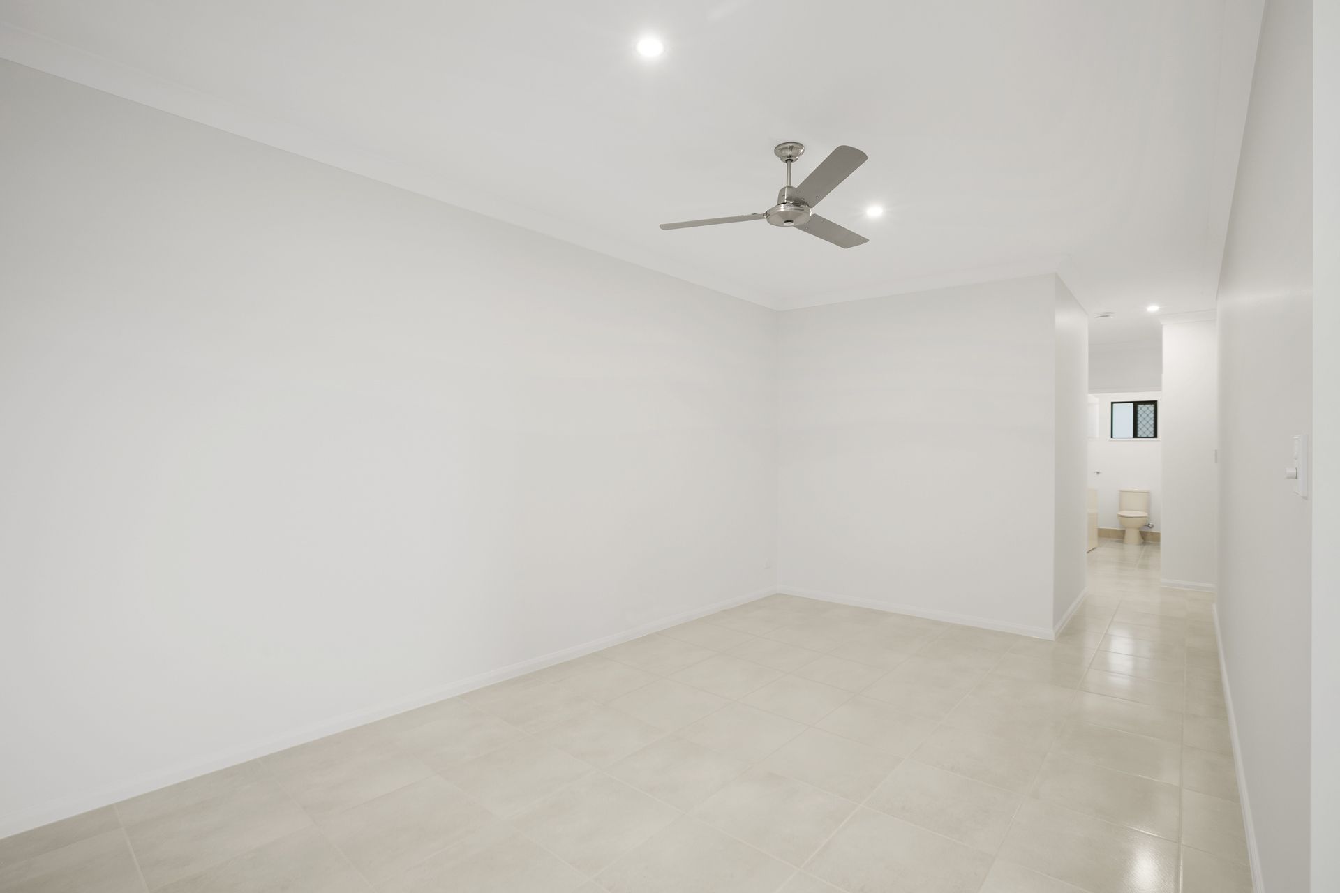 A Bright, Empty Room With White Walls, Tiled Floors — Ashlee Jones Homes in Gordonvale, QLD