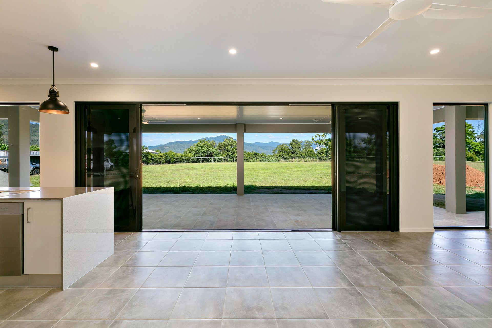 An Open-plan Room With Light Tile Floors — Ashlee Jones Homes in Gordonvale, QLD
