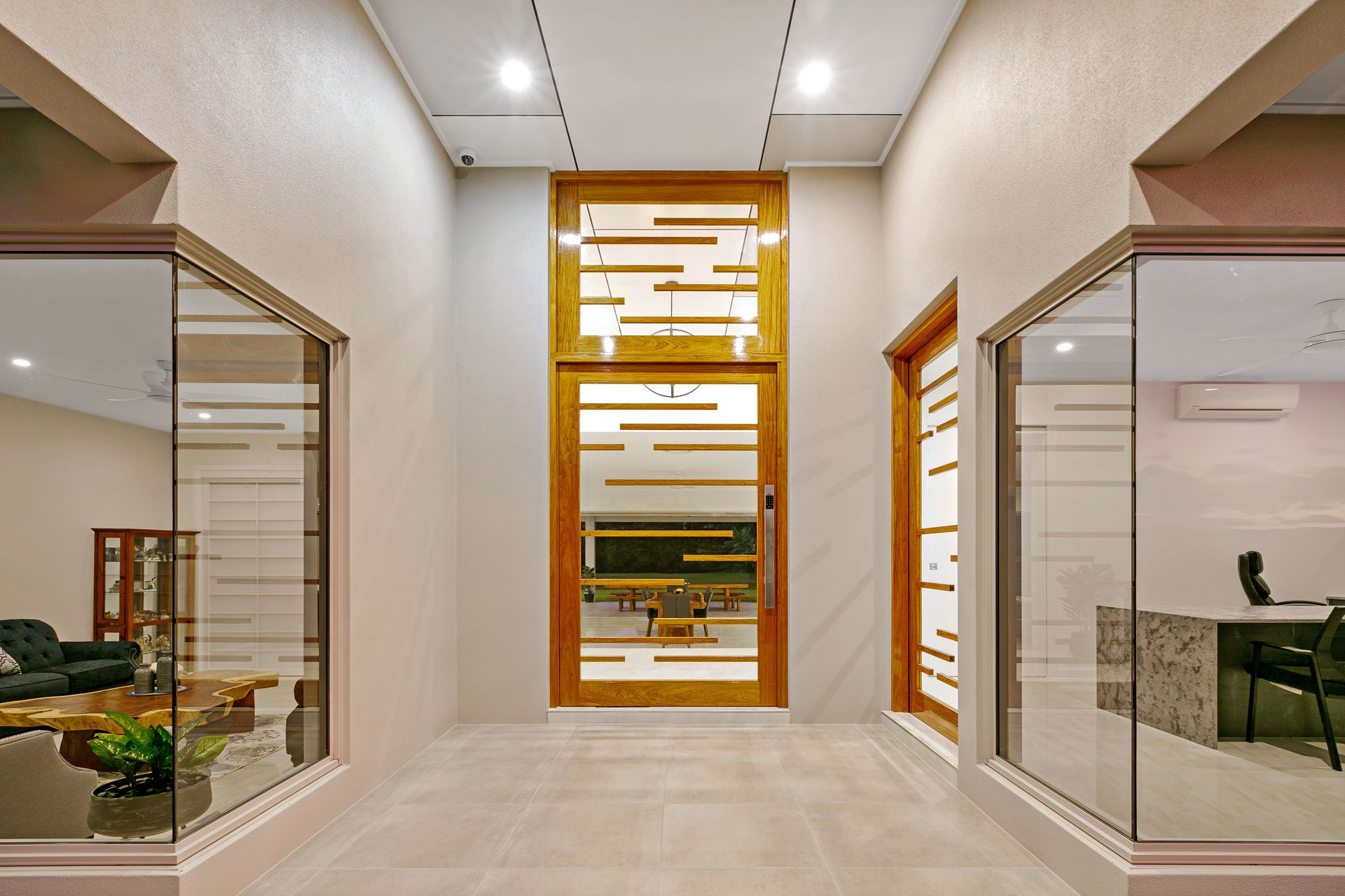 A Wide Entrance Hall With a Central Wood-framed Glass Door — Ashlee Jones Homes in Gordonvale, QLD