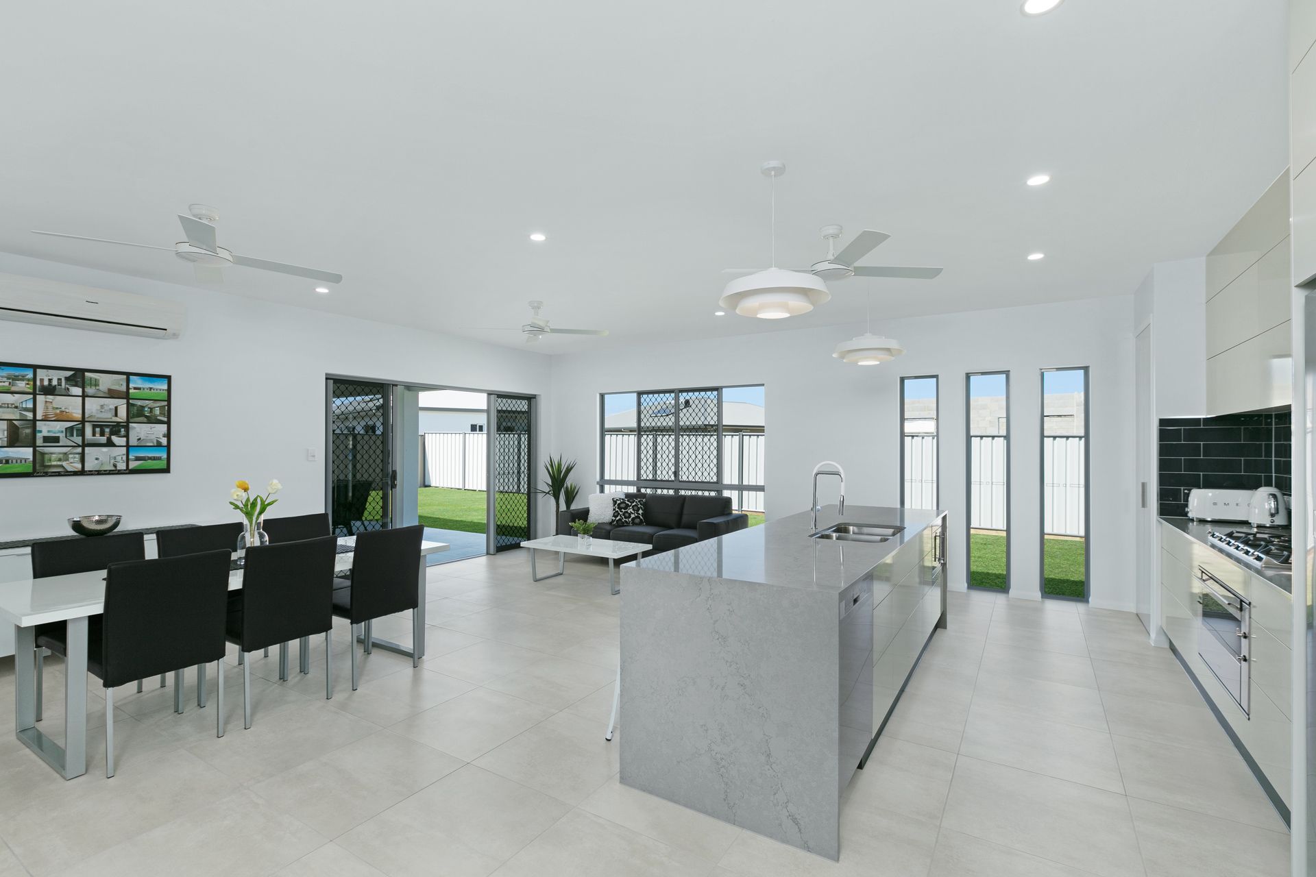 Modern, Open-plan Kitchen and Dining Area With Grey Kitchen Island — Ashlee Jones Homes in Gordonvale, QLD