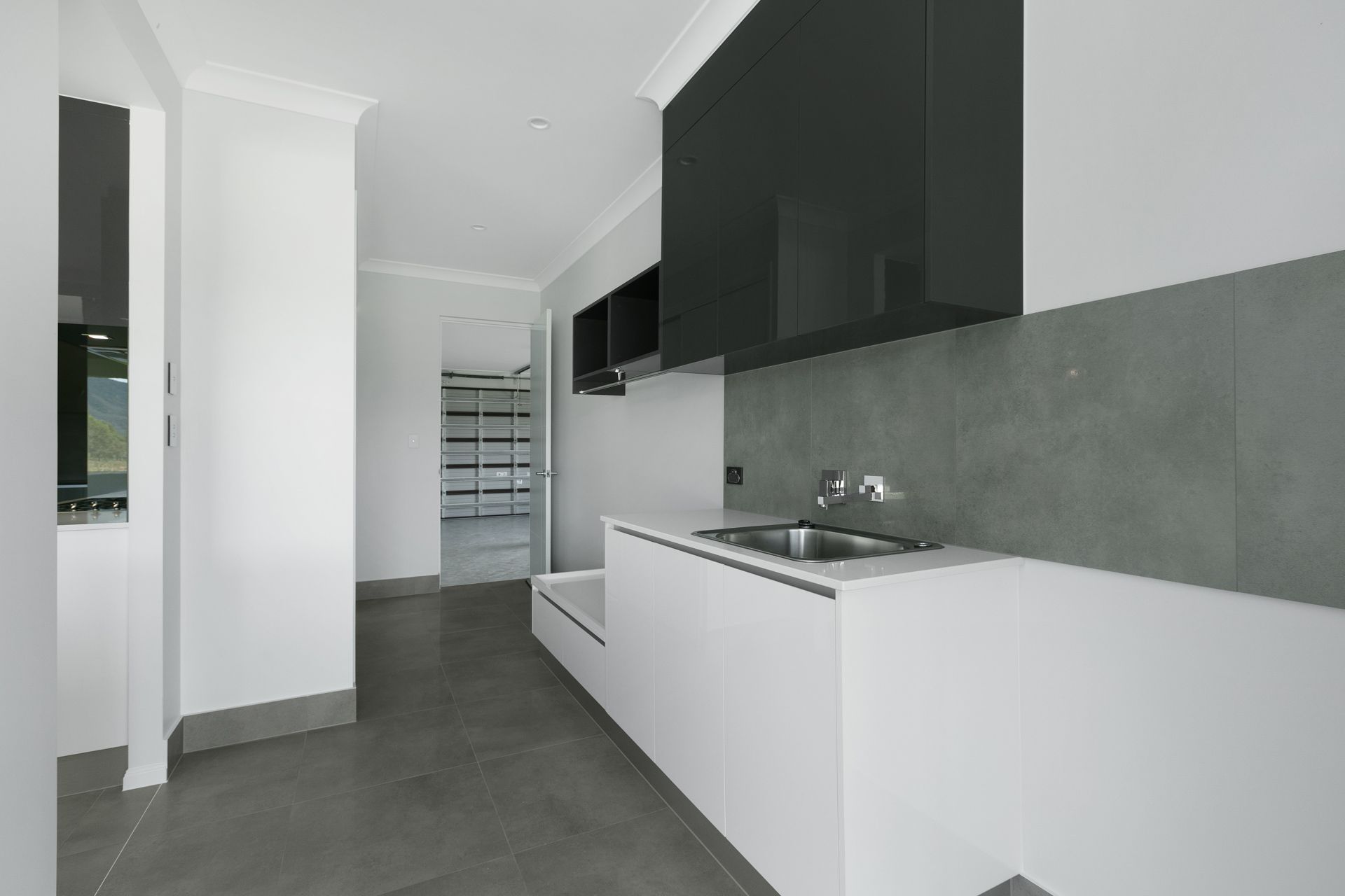 A Modern Laundry Room With White Cabinets — Ashlee Jones Homes in Gordonvale, QLD