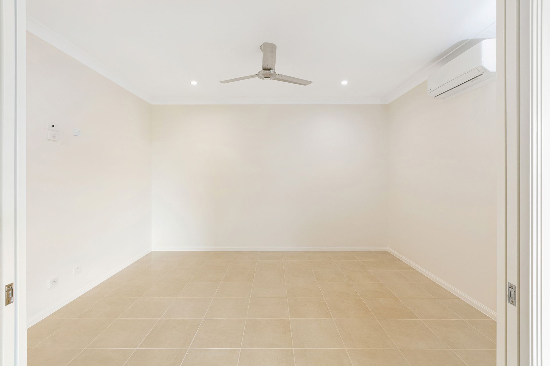 A Bright, Empty Room With Light-colored Tile Floors — Ashlee Jones Homes in Gordonvale, QLD