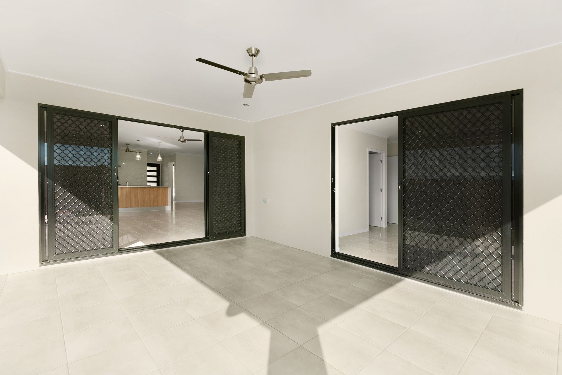A Modern Covered Patio With Large Sliding Glass Doors — Ashlee Jones Homes in Gordonvale, QLD