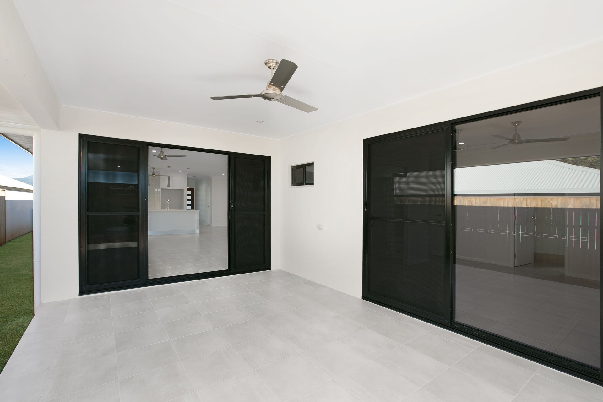 An Outdoor Patio With Light Tiled Flooring — Ashlee Jones Homes in Gordonvale, QLD