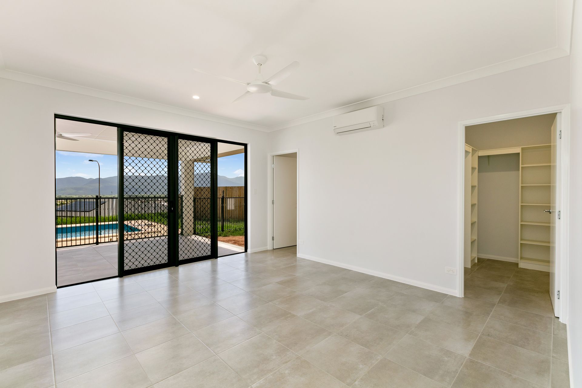 A Bright, Modern Room With Light Grey Tile Floors — Ashlee Jones Homes in Gordonvale, QLD