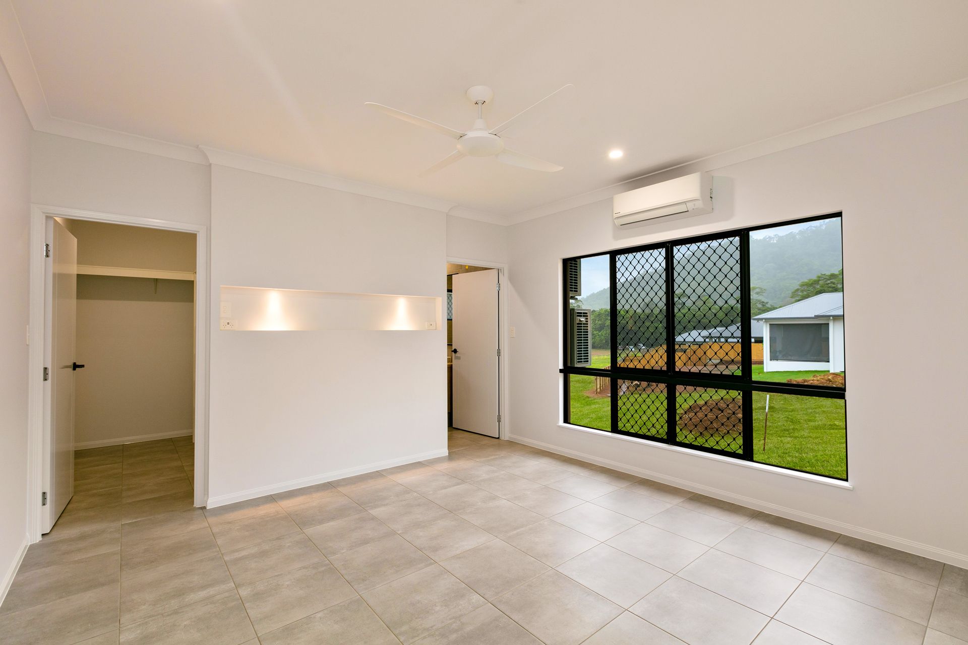 Empty, Minimalist Bedroom With Light Tile Floors — Ashlee Jones Homes in Gordonvale, QLD