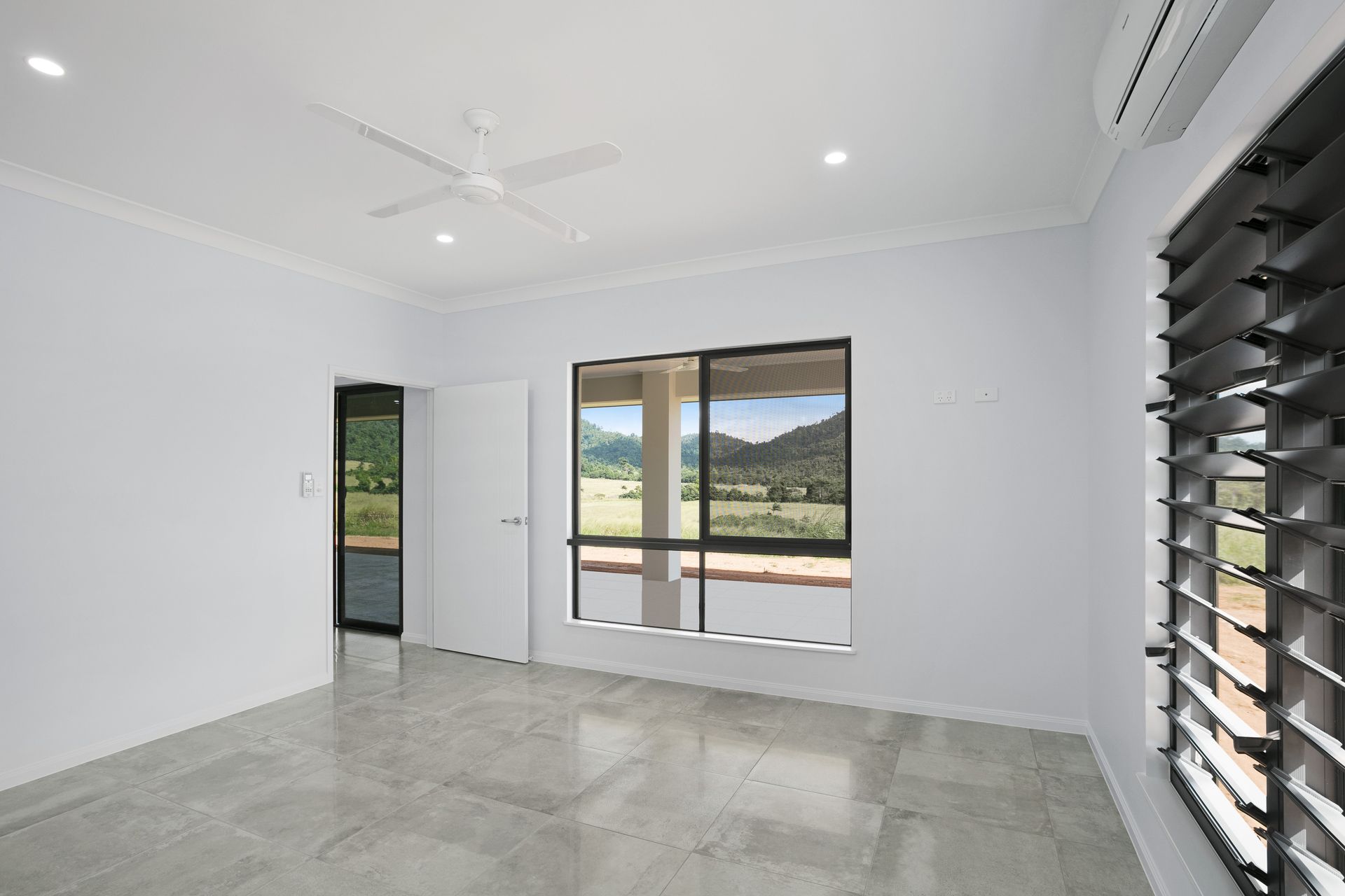 An Empty Room With White Walls, Light Gray Tile Floors — Ashlee Jones Homes in Gordonvale, QLD