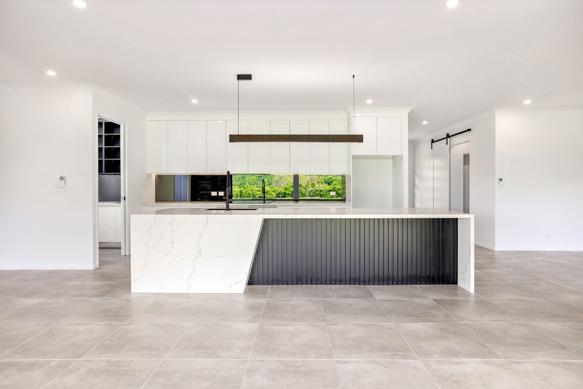 Modern Kitchen With a White Stone Island, Dark Fluted Base — Ashlee Jones Homes in Gordonvale, QLD