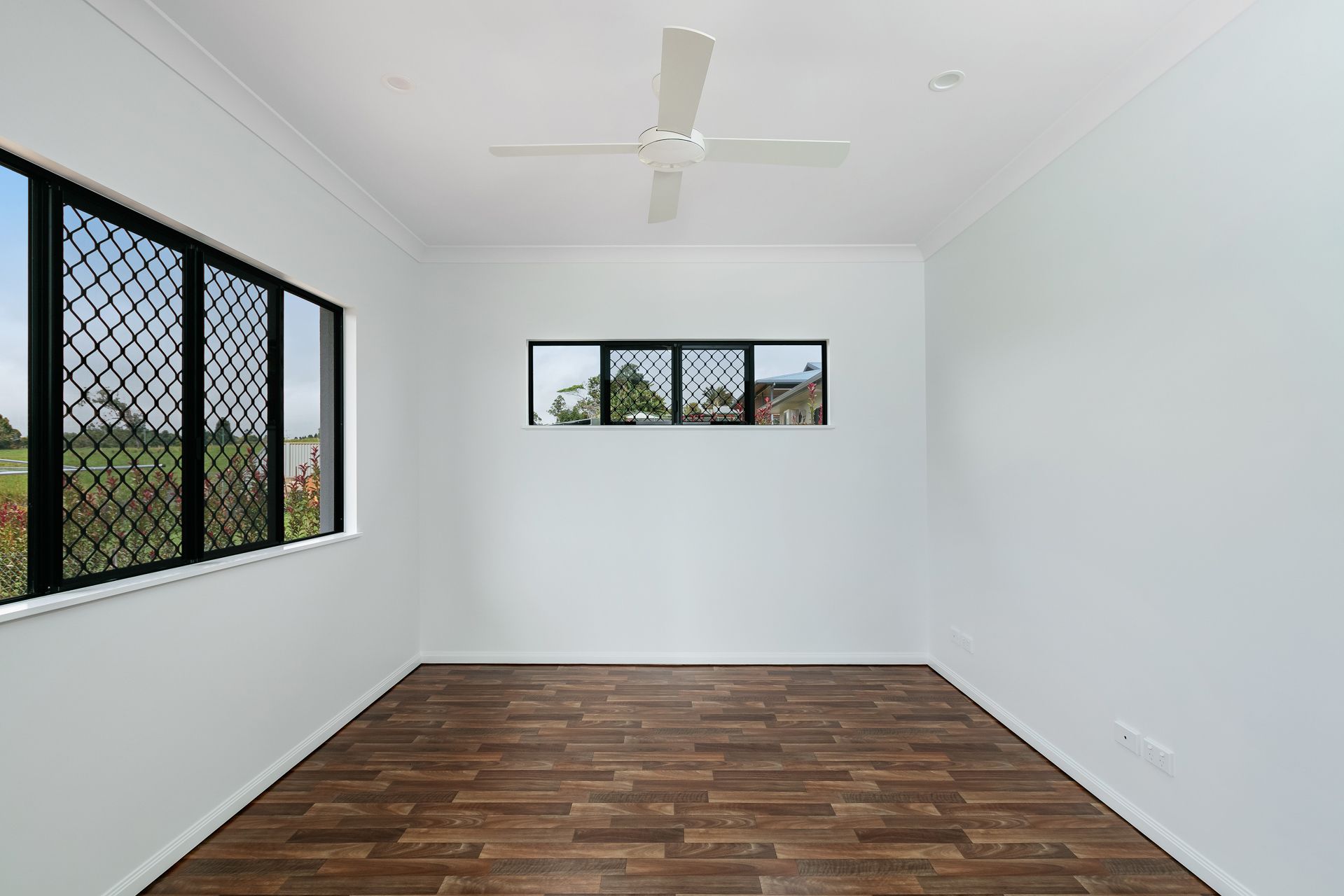 A Bright, Empty Room With White Walls, Wood-look Vinyl Flooring — Ashlee Jones Homes in Gordonvale, QLD