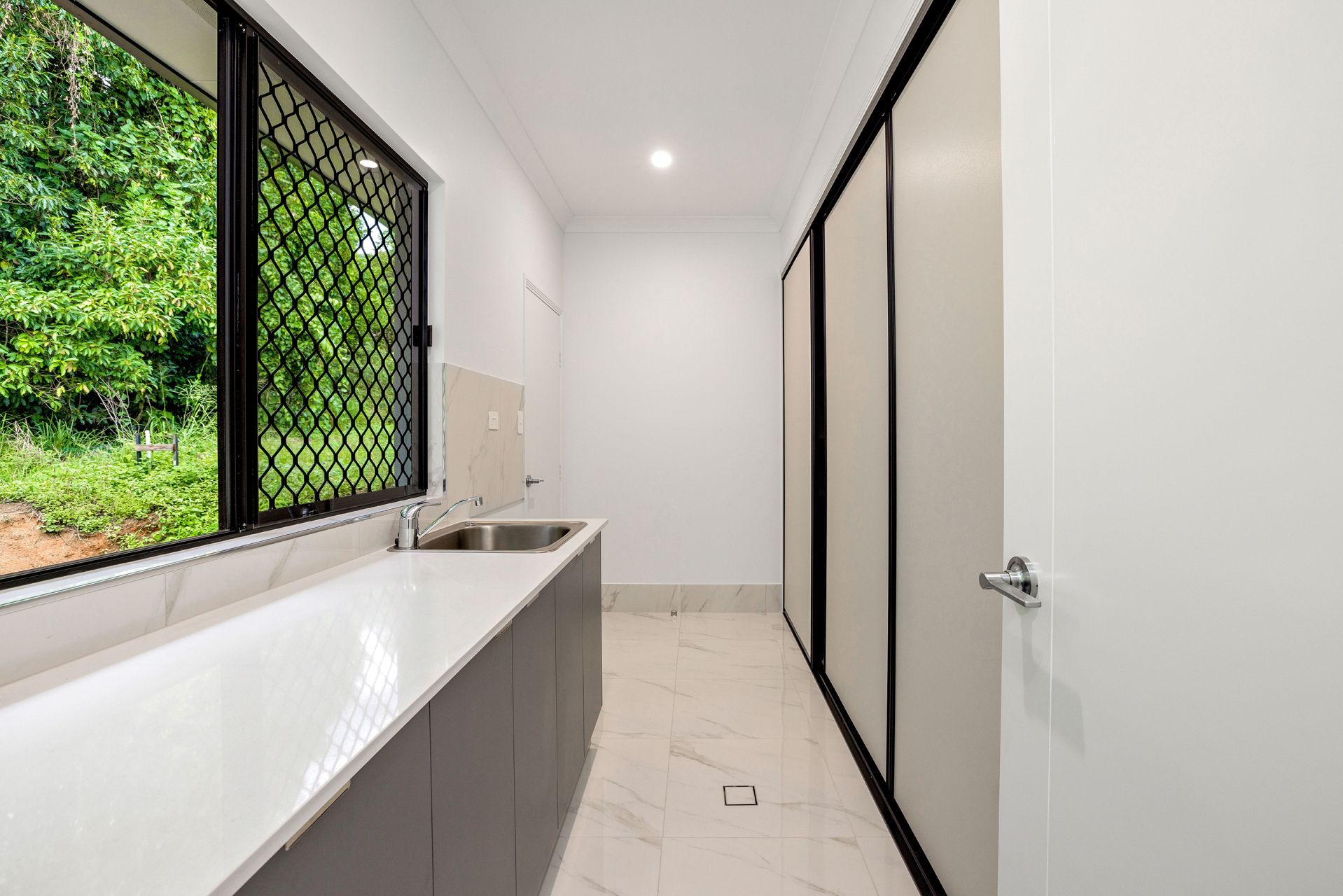 A Laundry Room With a White Countertop, Sink — Ashlee Jones Homes in Gordonvale, QLD