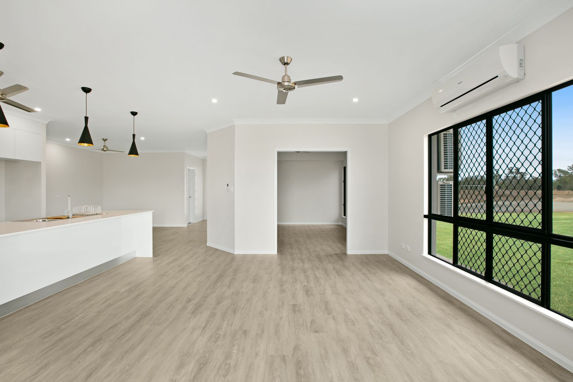 An Open-plan, Minimalist Room With Light Wood Floors — Ashlee Jones Homes in Gordonvale, QLD