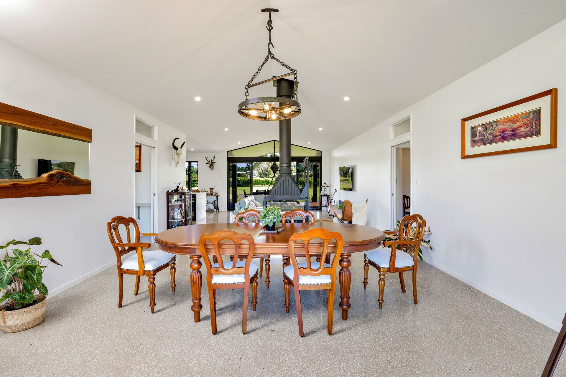 A Dining Room With a Wooden Table, Six Chairs, a Central Pendant Light — Ashlee Jones Homes in Gordonvale, QLD