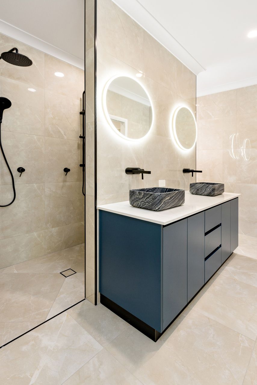A Modern Bathroom Featuring a Blue Double Vanity — Ashlee Jones Homes in Gordonvale, QLD