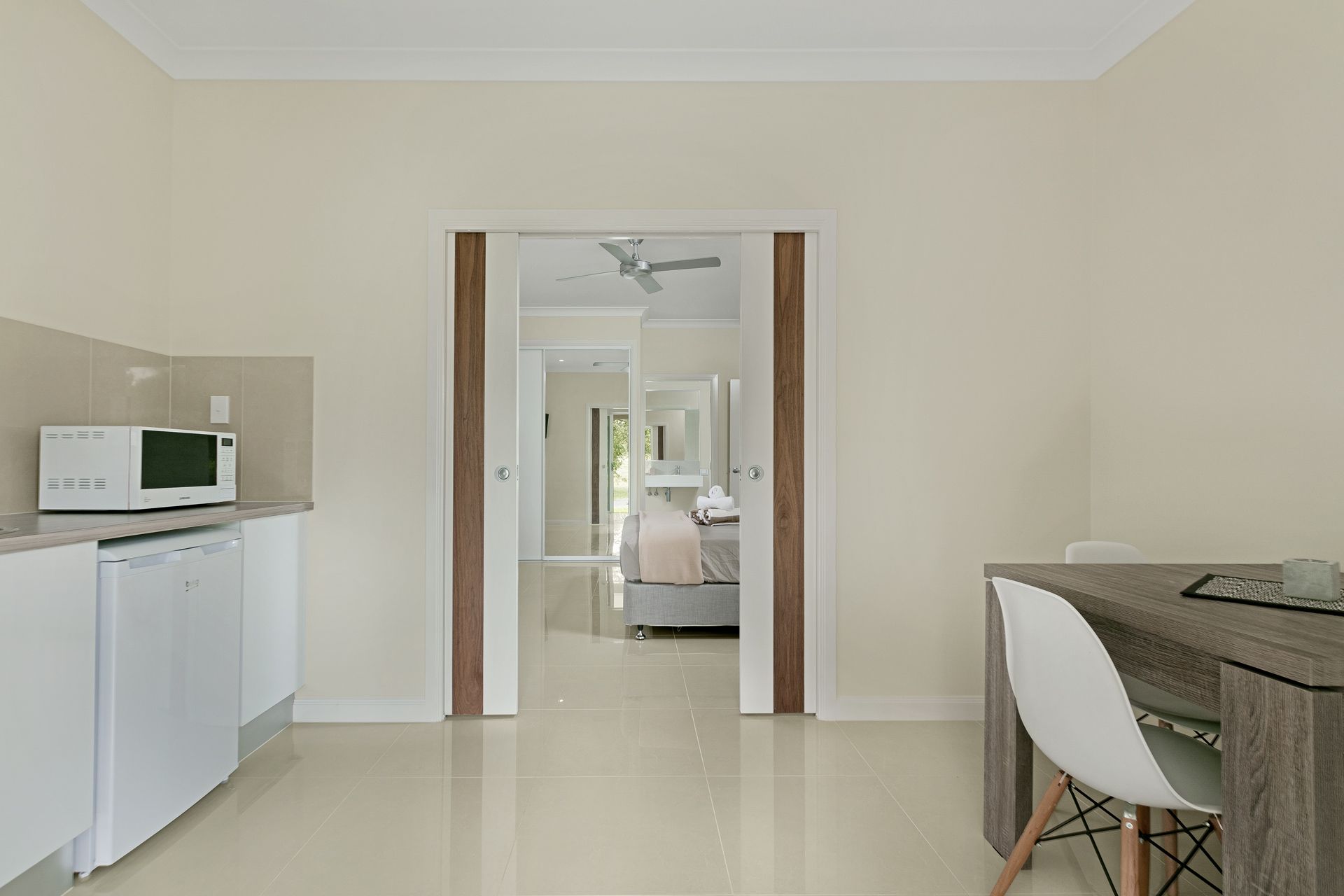 A Kitchen Area With White Cabinets and a Microwave — Ashlee Jones Homes in Gordonvale, QLD