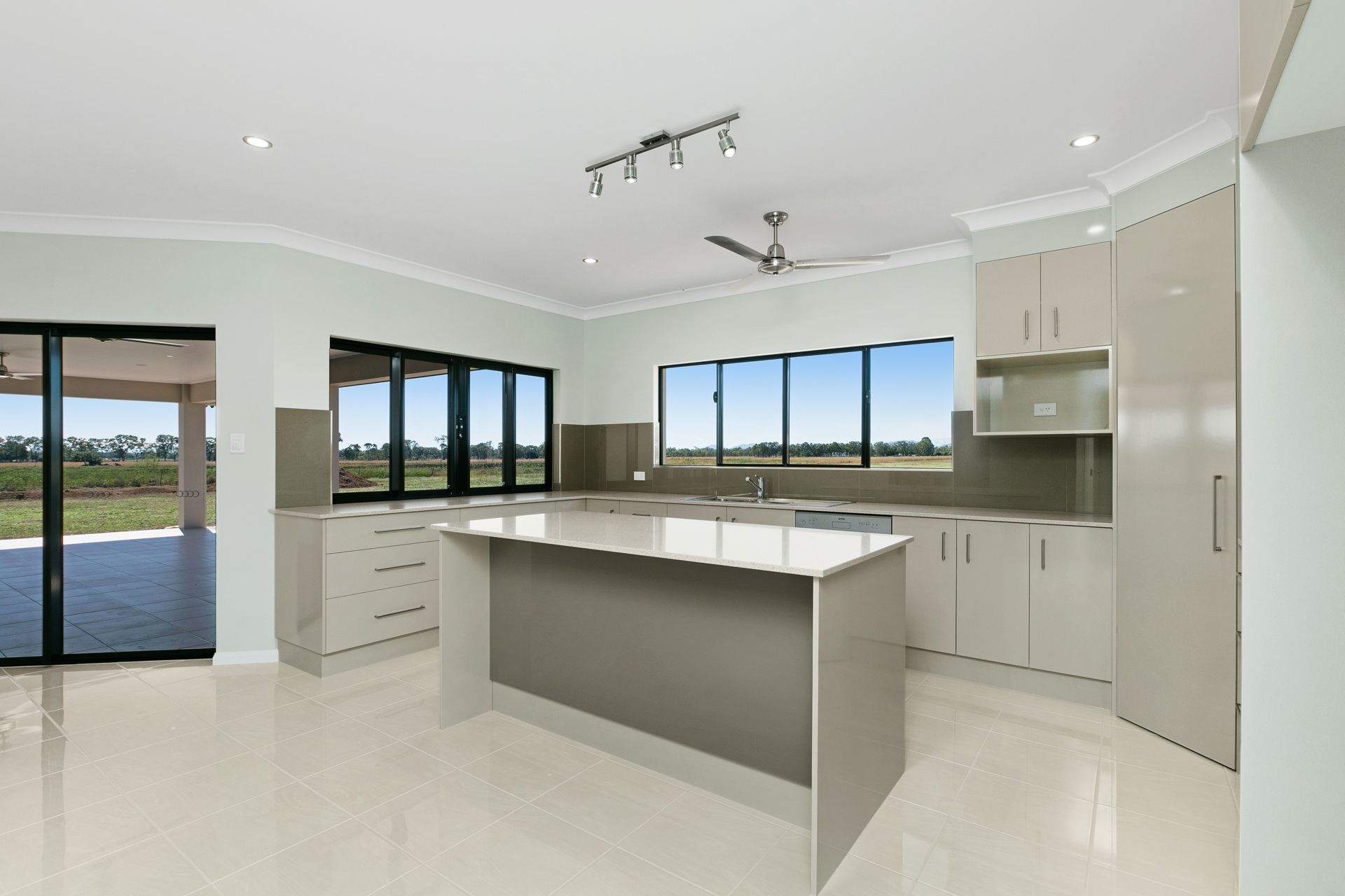 A Modern Kitchen With Light Cabinetry, a Central Island — Ashlee Jones Homes in Gordonvale, QLD