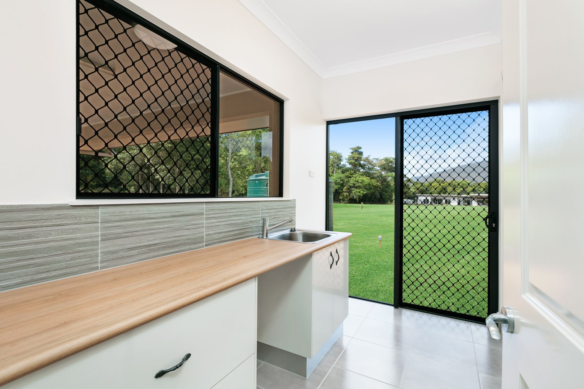 A Bright Laundry Room With a Light Wood Countertop — Ashlee Jones Homes in Gordonvale, QLD
