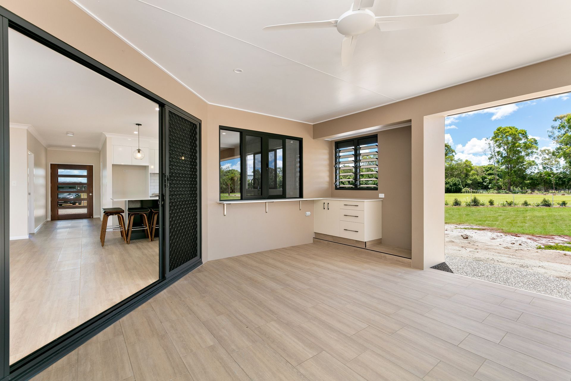 A Covered Outdoor Patio With Light Wood Flooring — Ashlee Jones Homes in Gordonvale, QLD