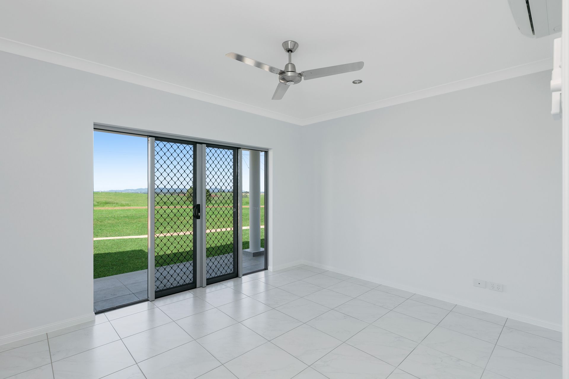 A Bright, Empty Room With White Walls, Tiled Floors — Ashlee Jones Homes in Gordonvale, QLD