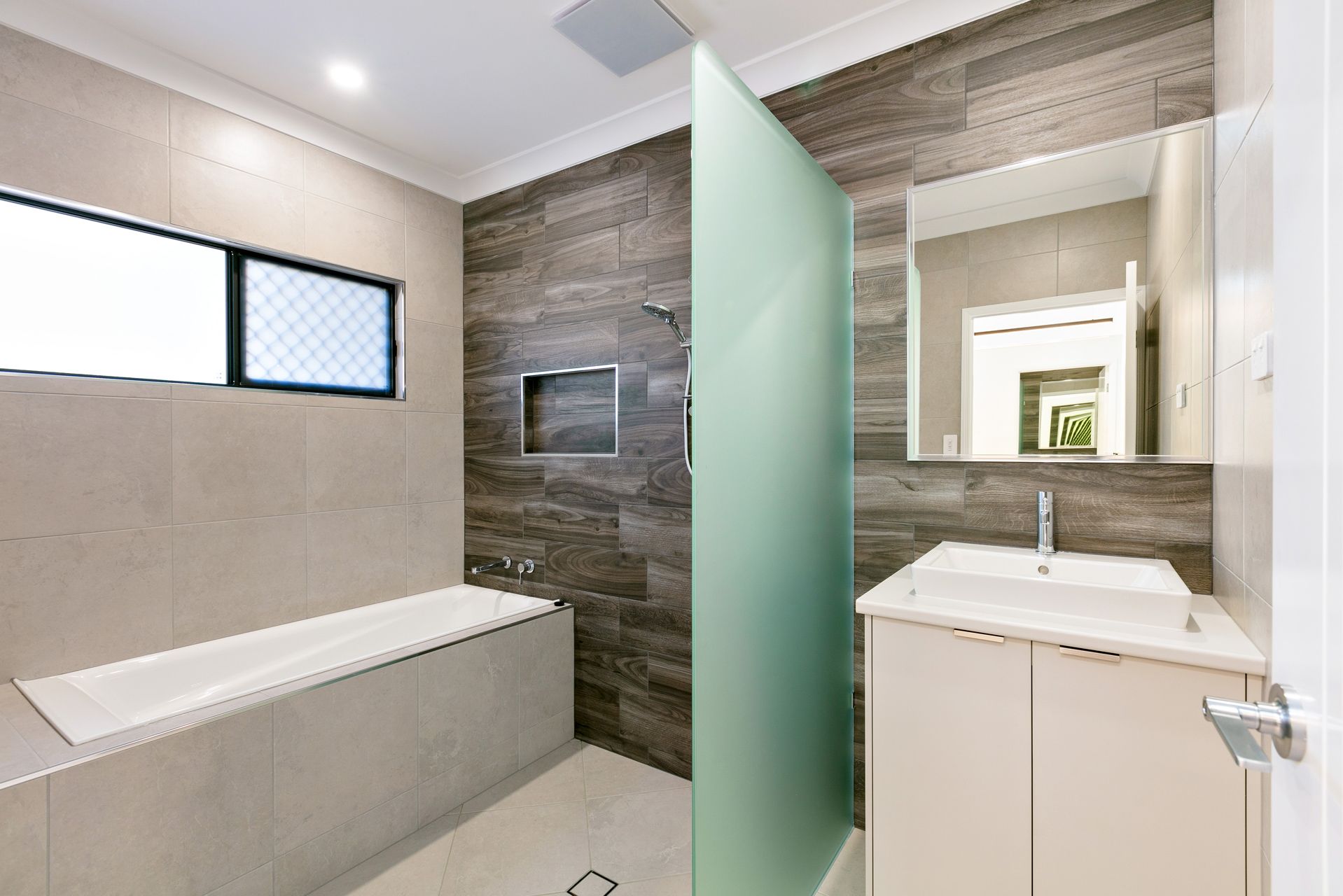 A Modern Bathroom Featuring a White Bathtub — Ashlee Jones Homes in Gordonvale, QLD
