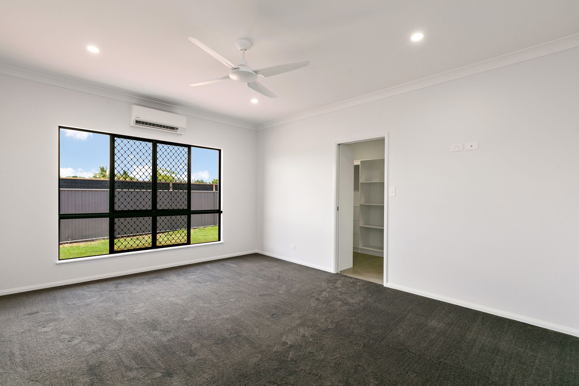 An Unfurnished Room With White Walls, Dark Gray Carpeting — Ashlee Jones Homes in Gordonvale, QLD