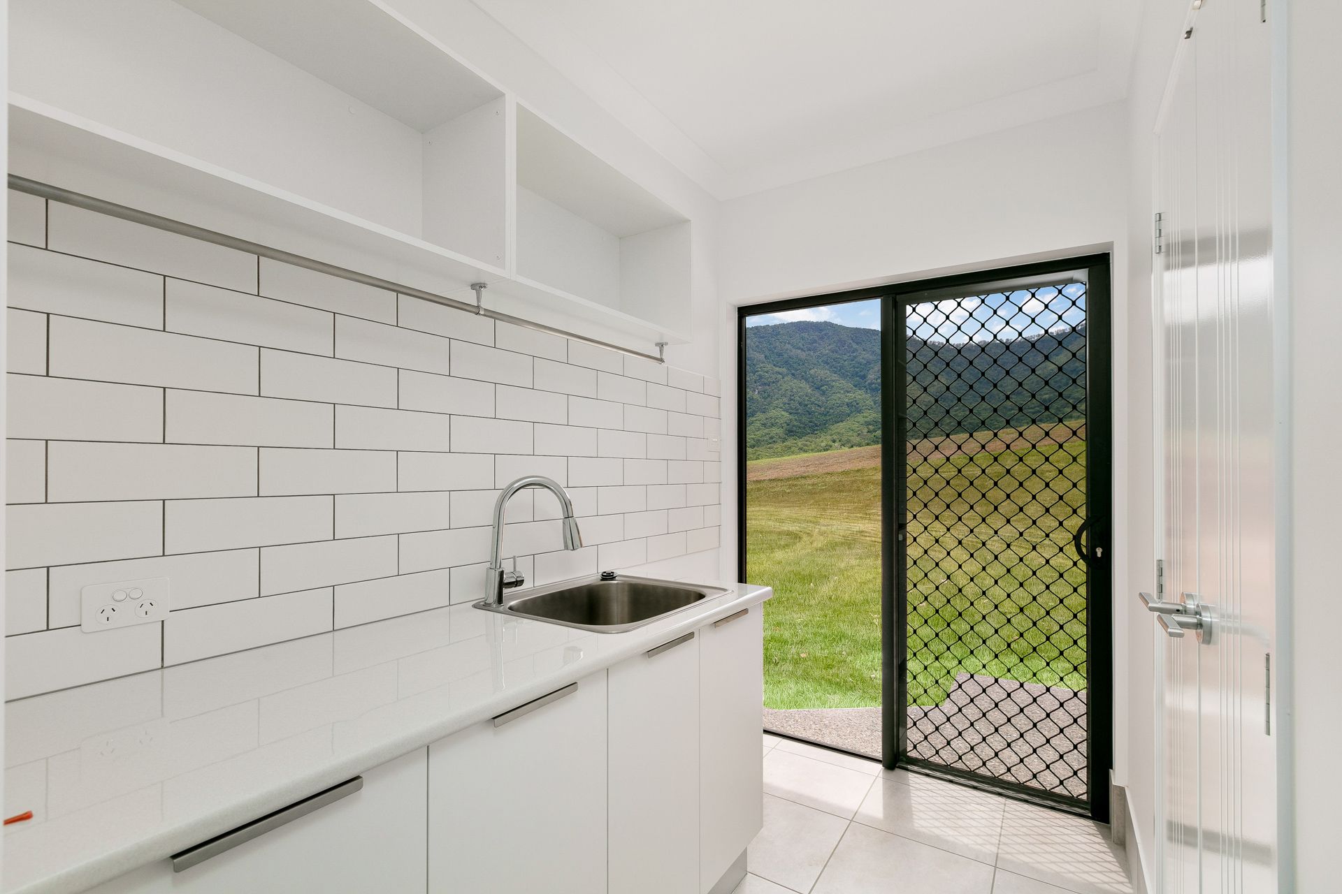 A Bright Laundry Room With White Subway Tile — Ashlee Jones Homes in Gordonvale, QLD