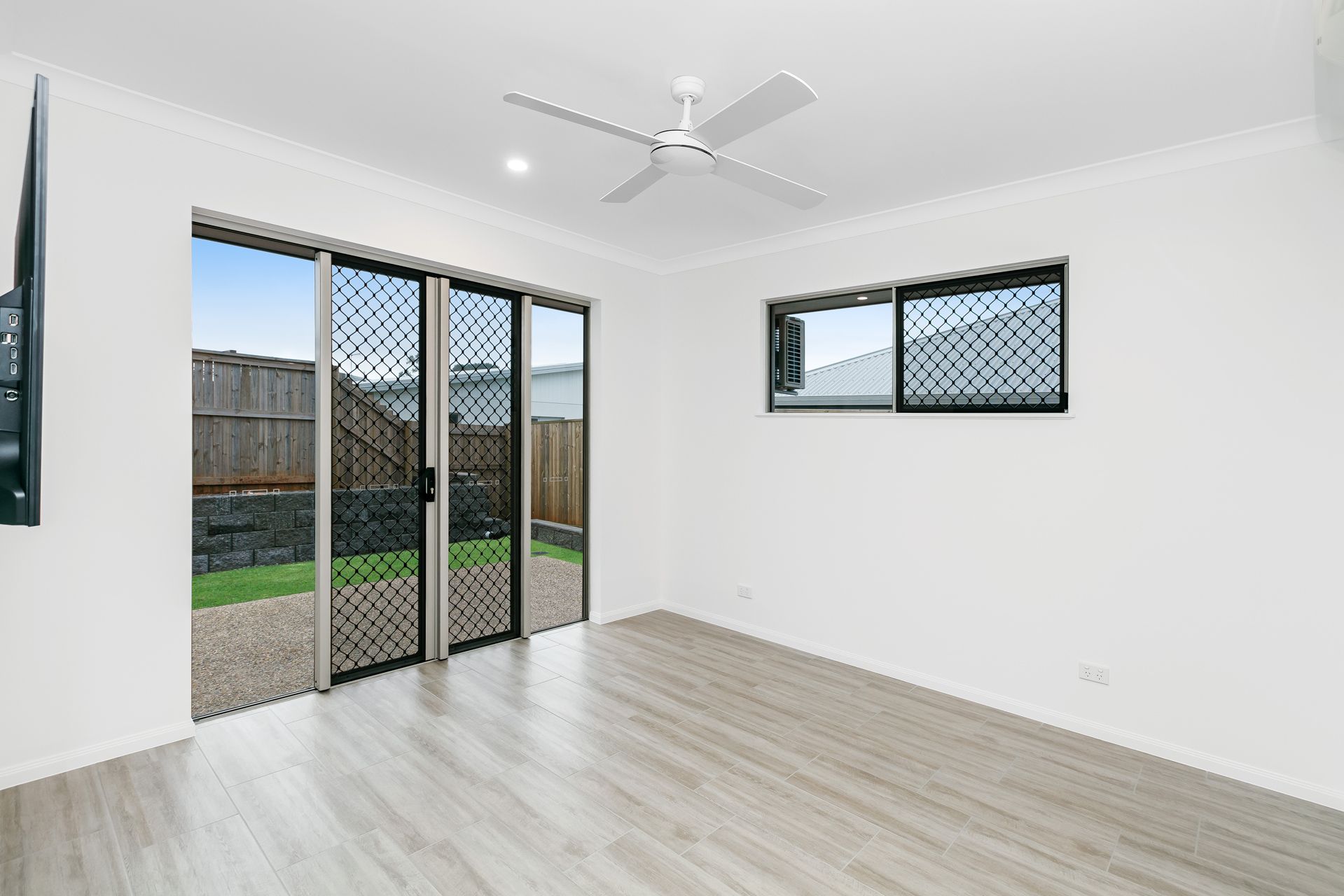 A Bright, Empty Room With Light Wood-look Flooring — Ashlee Jones Homes in Gordonvale, QLD