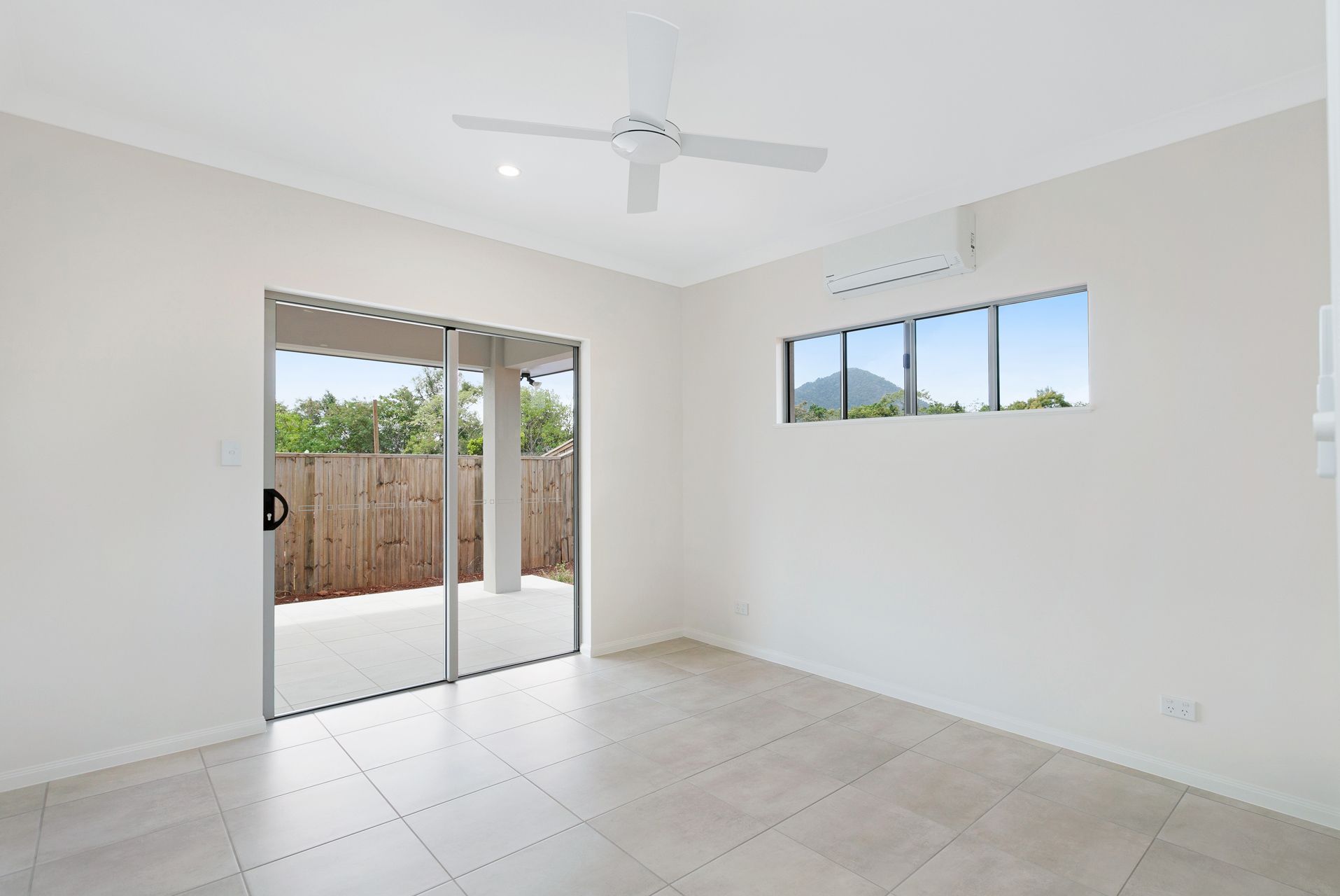 A Bright, Empty Room With White Walls, Light-colored Tile Floors — Ashlee Jones Homes in Gordonvale, QLD