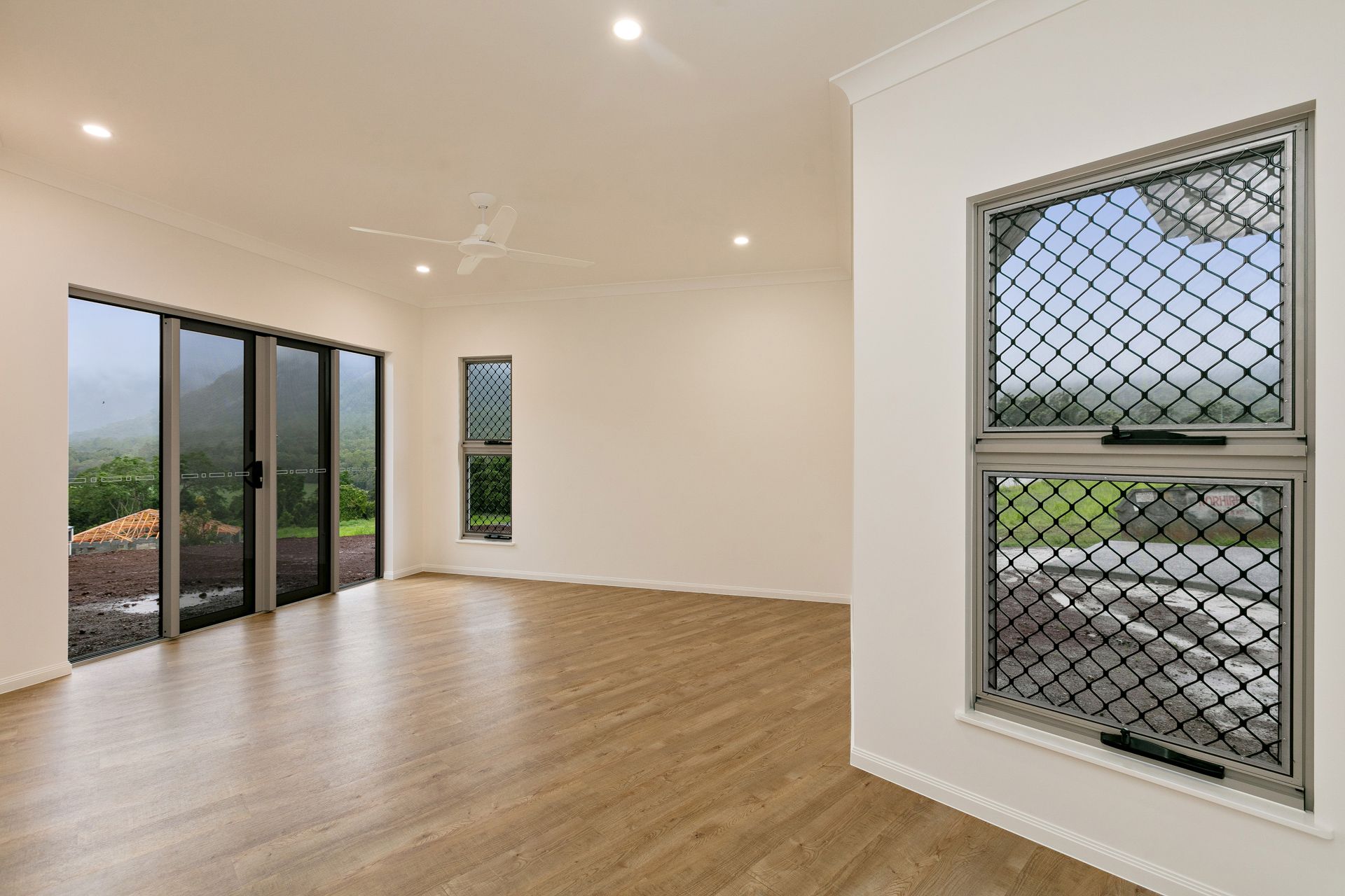 An Empty, Modern Room With Light Wood Flooring — Ashlee Jones Homes in Gordonvale, QLD