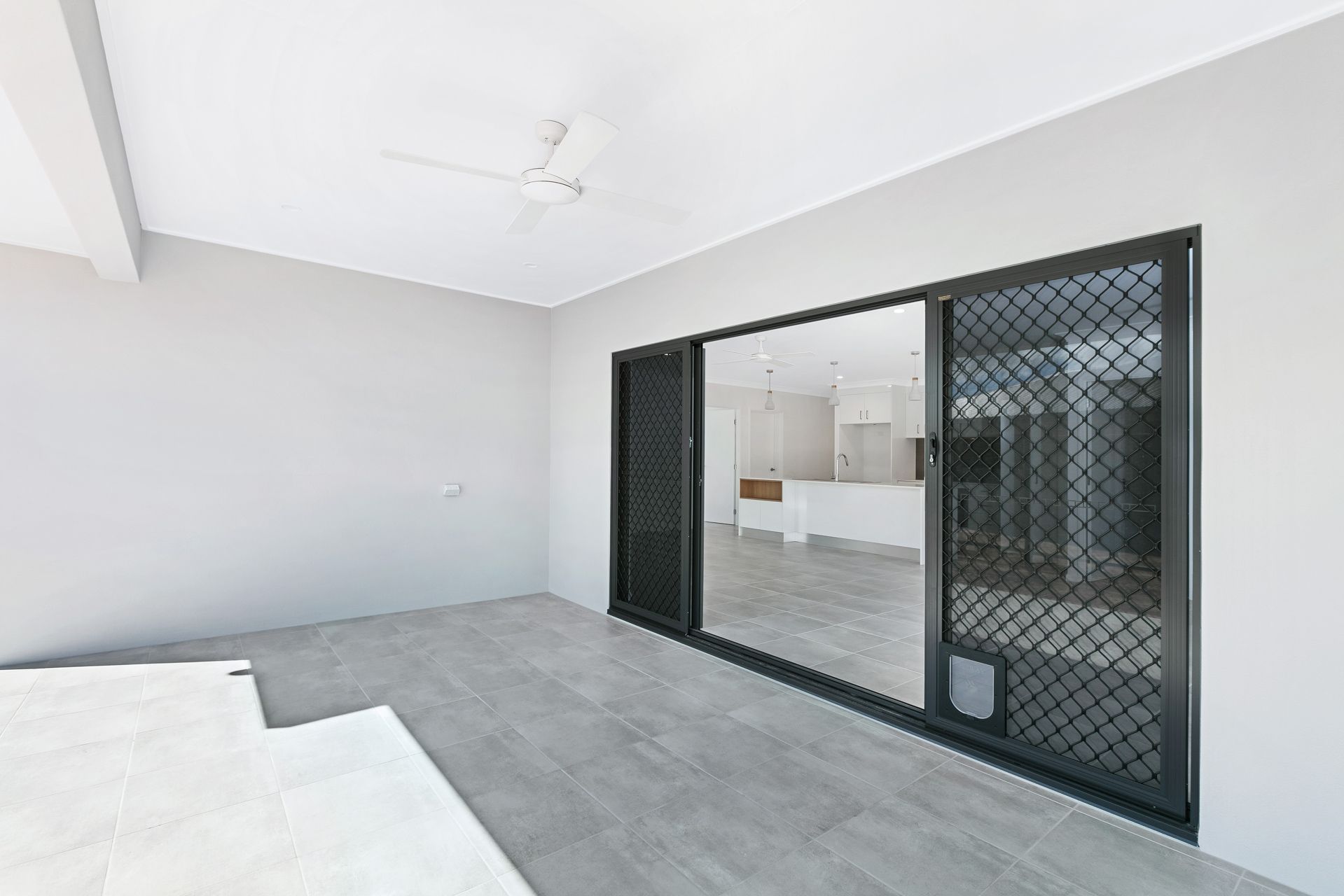A Covered Concrete Patio With a Ceiling Fan — Ashlee Jones Homes in Gordonvale, QLD