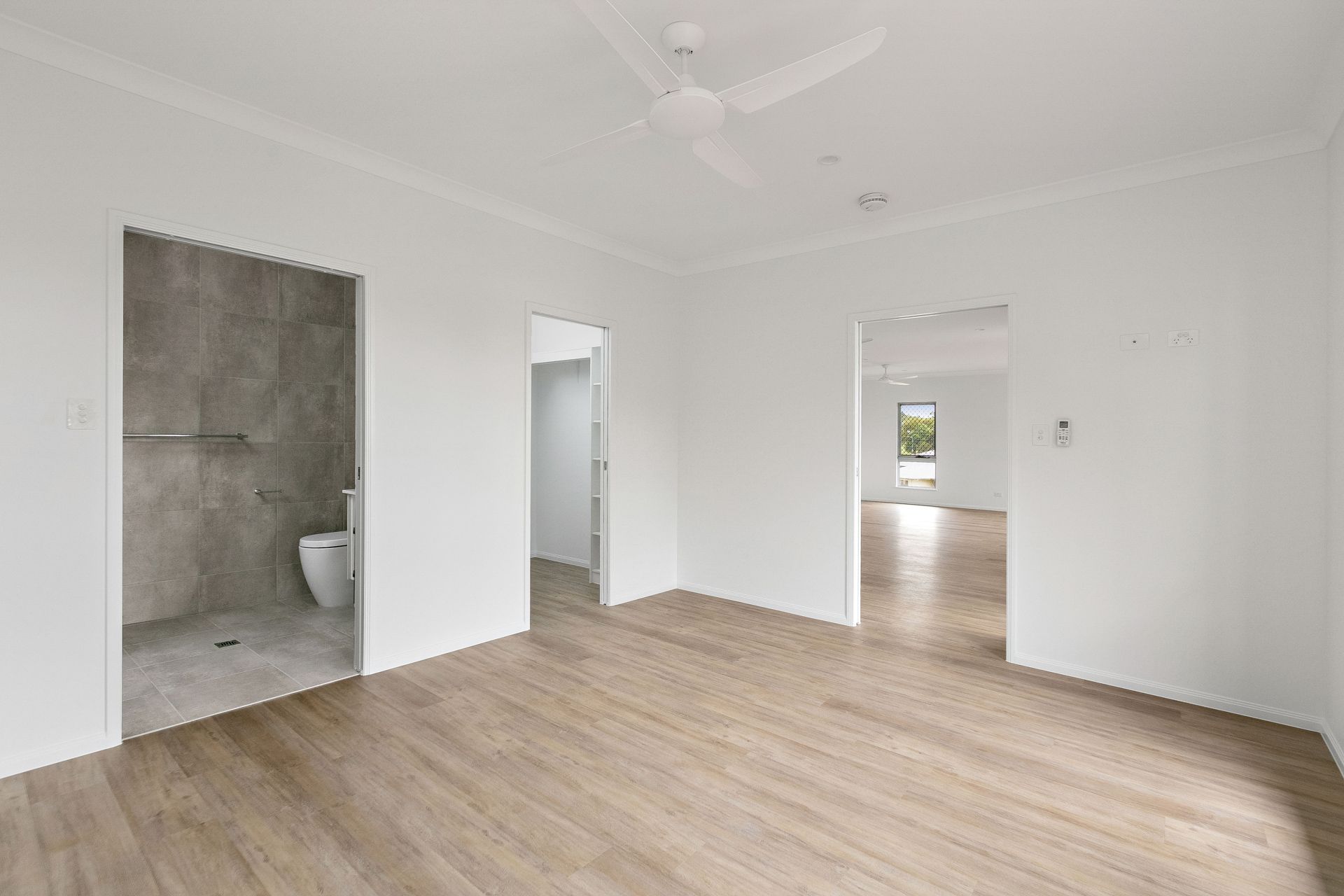 An Empty Room With Light Wood Flooring — Ashlee Jones Homes in Gordonvale, QLD