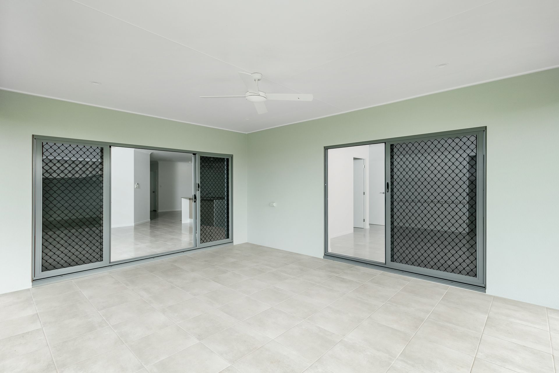 Empty Covered Patio With Light Grey Tile Flooring — Ashlee Jones Homes in Gordonvale, QLD