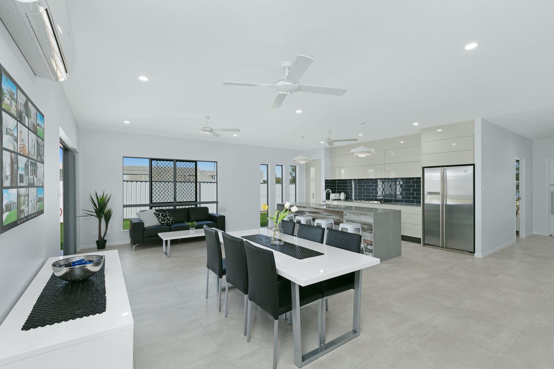 A Modern, Open-plan Living and Dining Room With a White Table — Ashlee Jones Homes in Gordonvale, QLD
