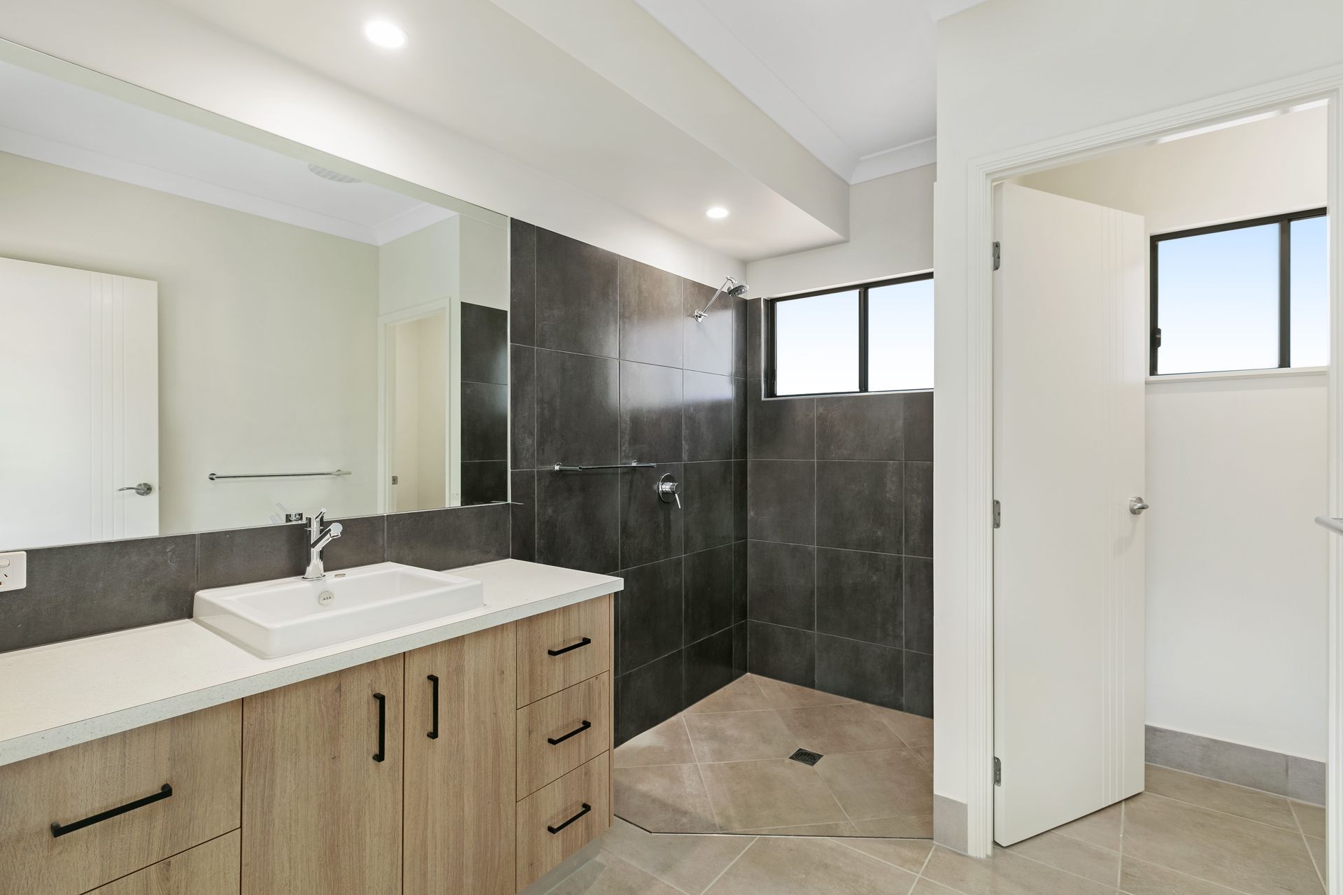 A Modern Bathroom With a Light Wood Vanity — Ashlee Jones Homes in Gordonvale, QLD