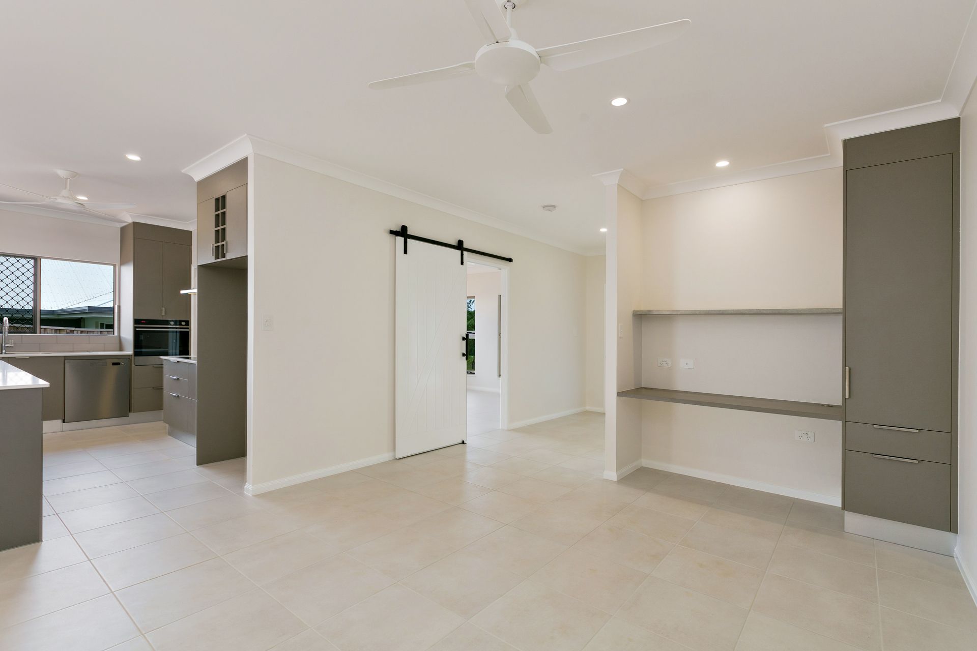 A Modern Kitchen Area With Light Walls, Tiled Floors — Ashlee Jones Homes in Gordonvale, QLD