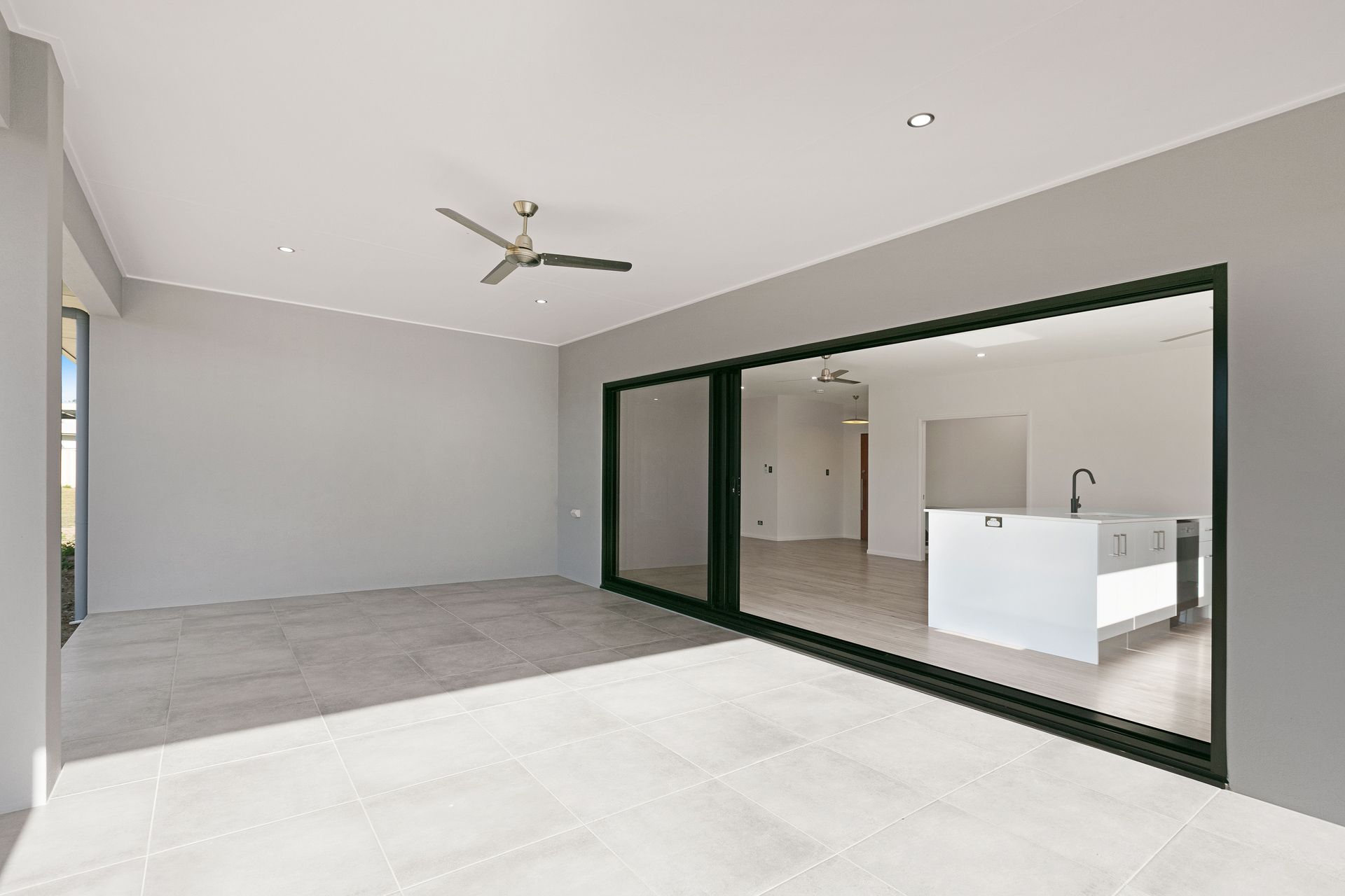 A Bright, Modern Covered Patio With Large Glass Sliding Doors — Ashlee Jones Homes in Gordonvale, QLD