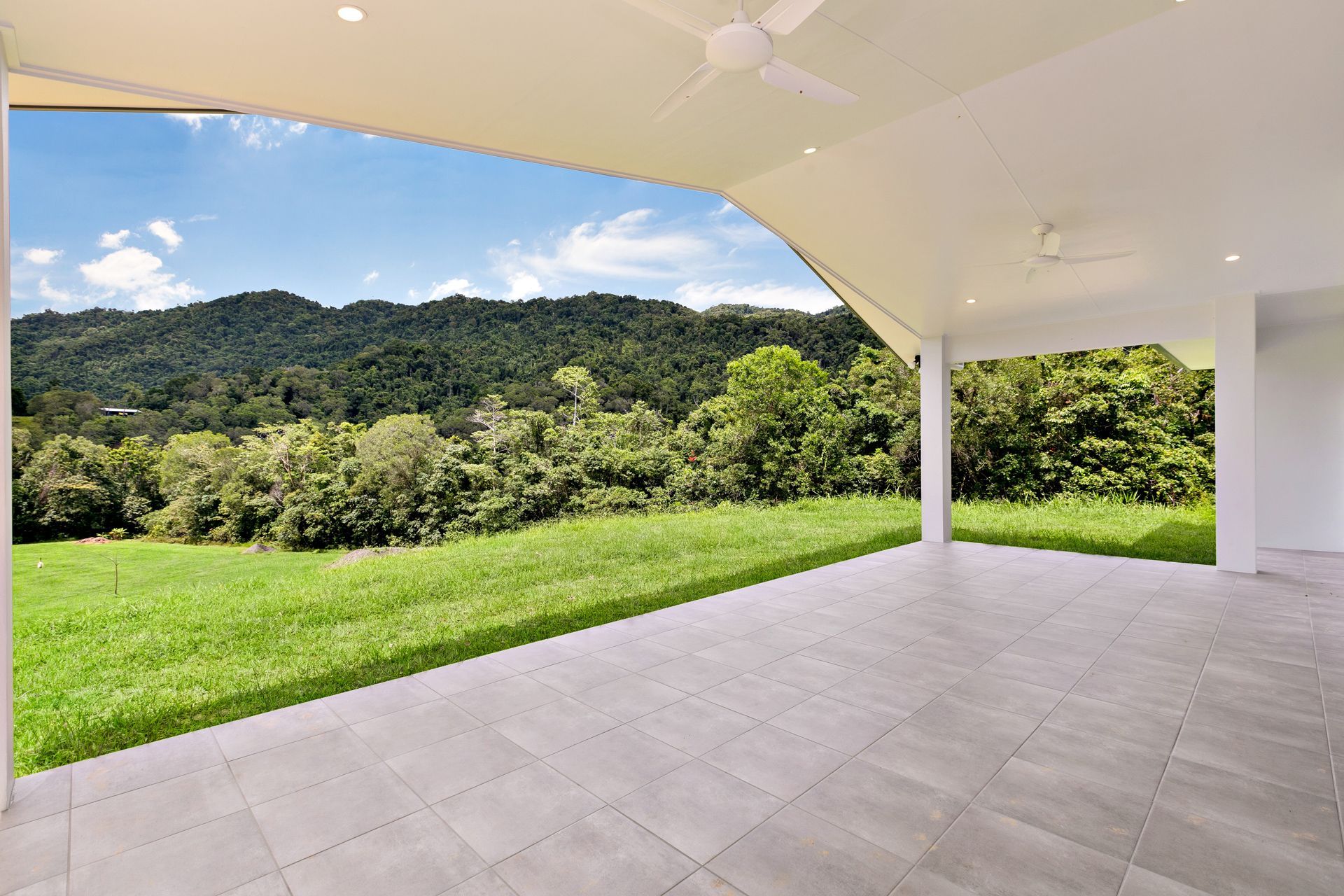 A Covered Patio With Light Grey Tiled Flooring — Ashlee Jones Homes in Gordonvale, QLD