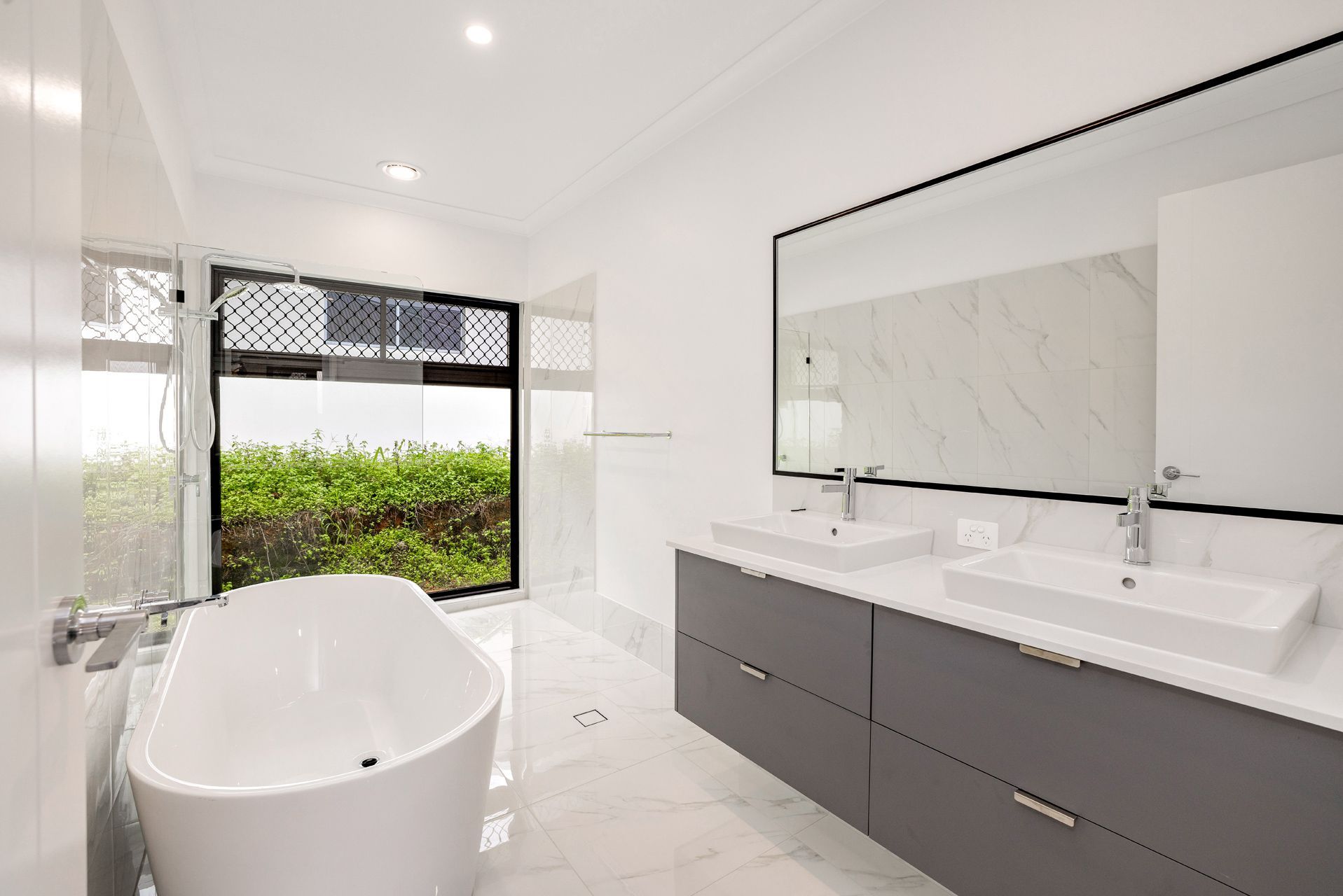 A Modern, Bright Bathroom With a White Freestanding Tub — Ashlee Jones Homes in Gordonvale, QLD