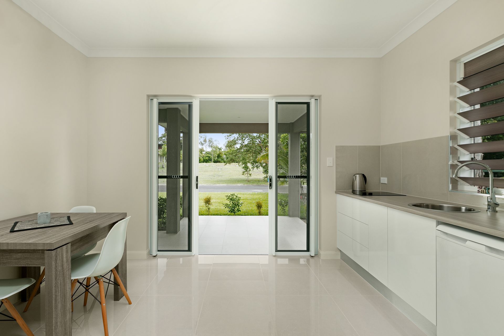 A Bright, Minimalist Kitchen With a Dining Set — Ashlee Jones Homes in Gordonvale, QLD