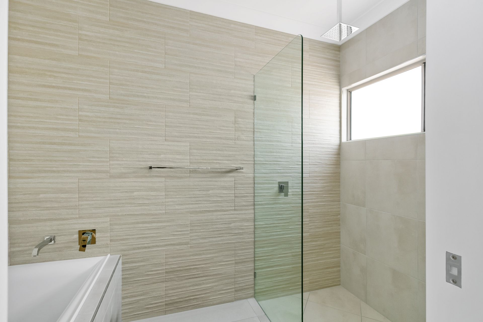 A Modern Bathroom Featuring a White Bathtub — Ashlee Jones Homes in Gordonvale, QLD