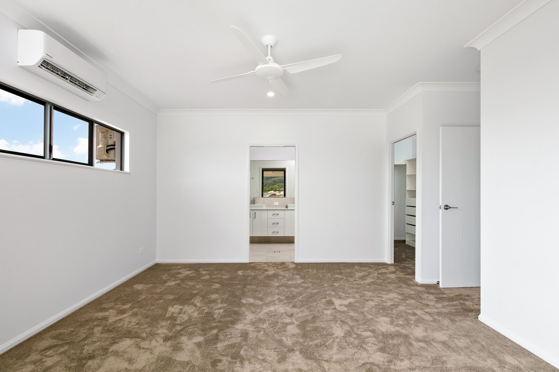 A Bright, Empty Bedroom With White Walls — Ashlee Jones Homes in Gordonvale, QLD