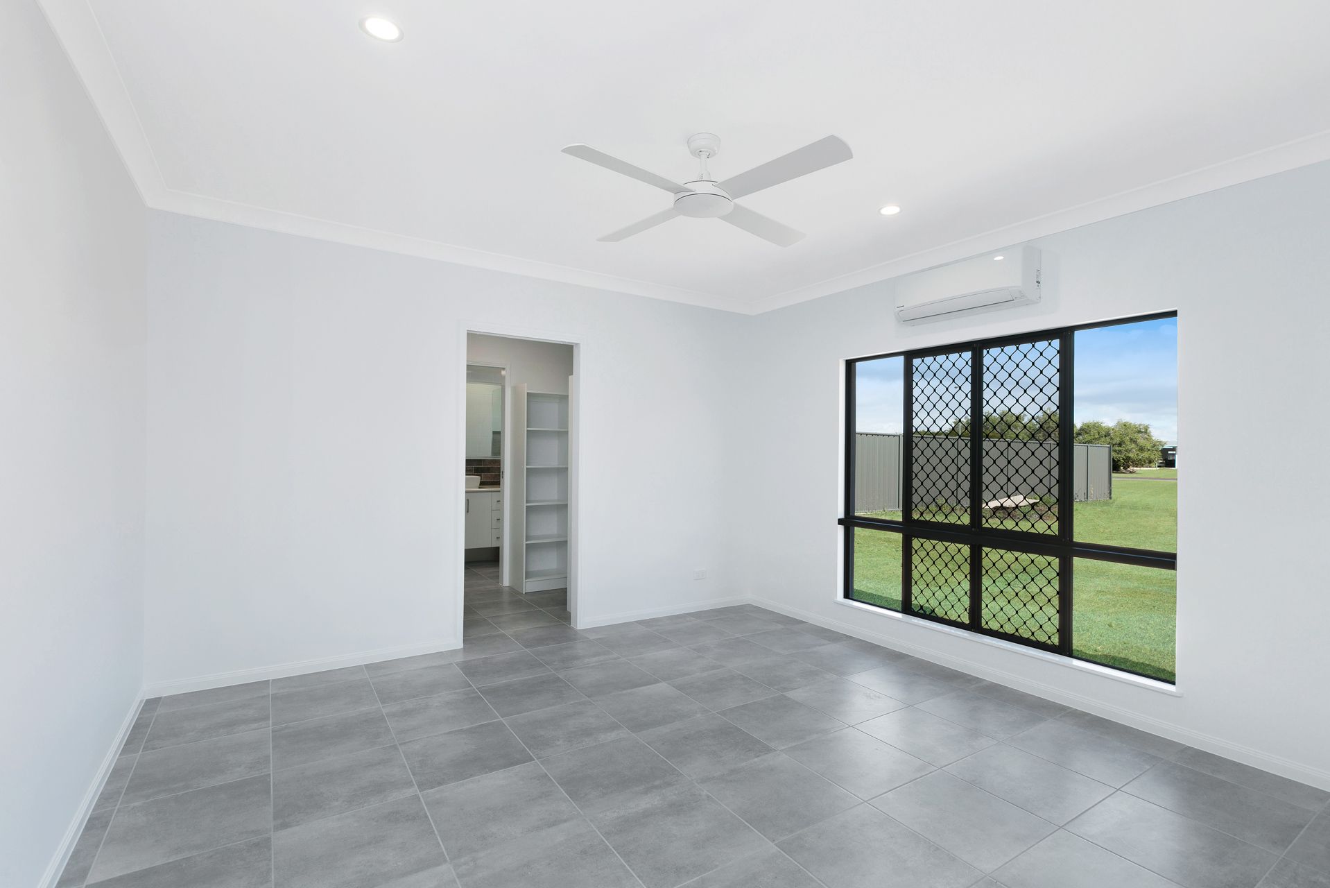 Empty Modern Room With Grey Tiled Floors — Ashlee Jones Homes in Gordonvale, QLD