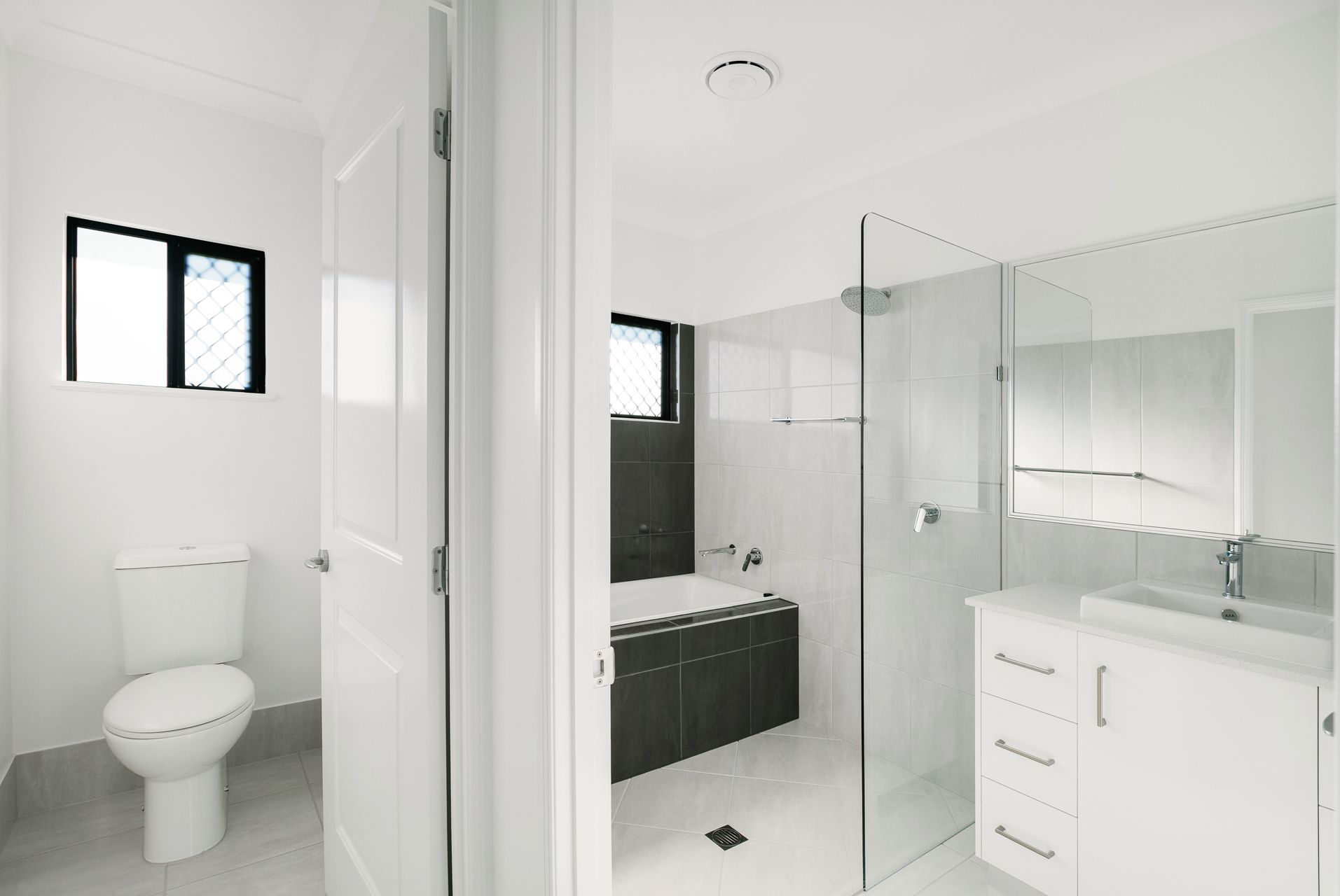 A Modern Bathroom Featuring a White Vanity — Ashlee Jones Homes in Gordonvale, QLD