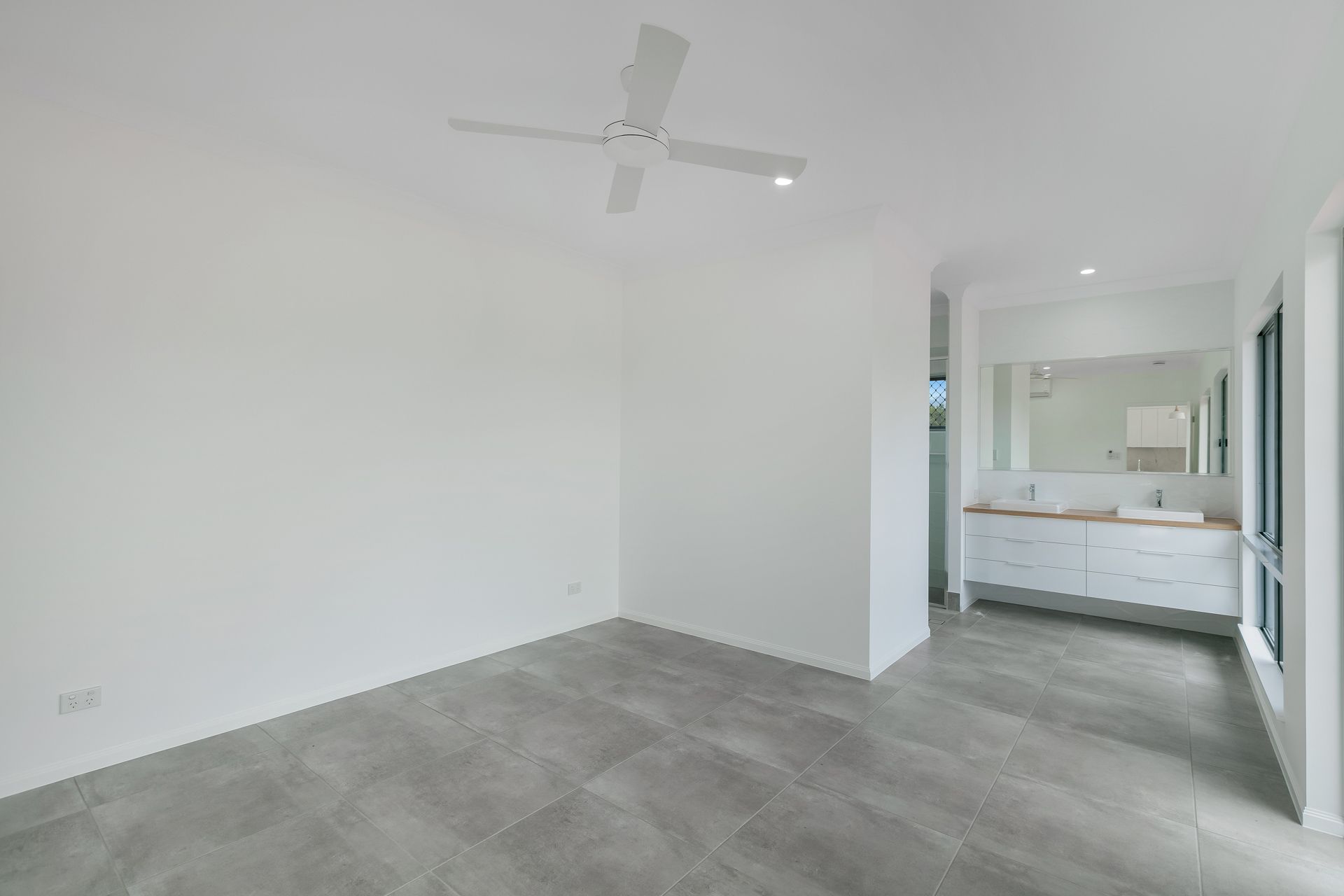 An Empty Room With Gray Tile Floors — Ashlee Jones Homes in Gordonvale, QLD