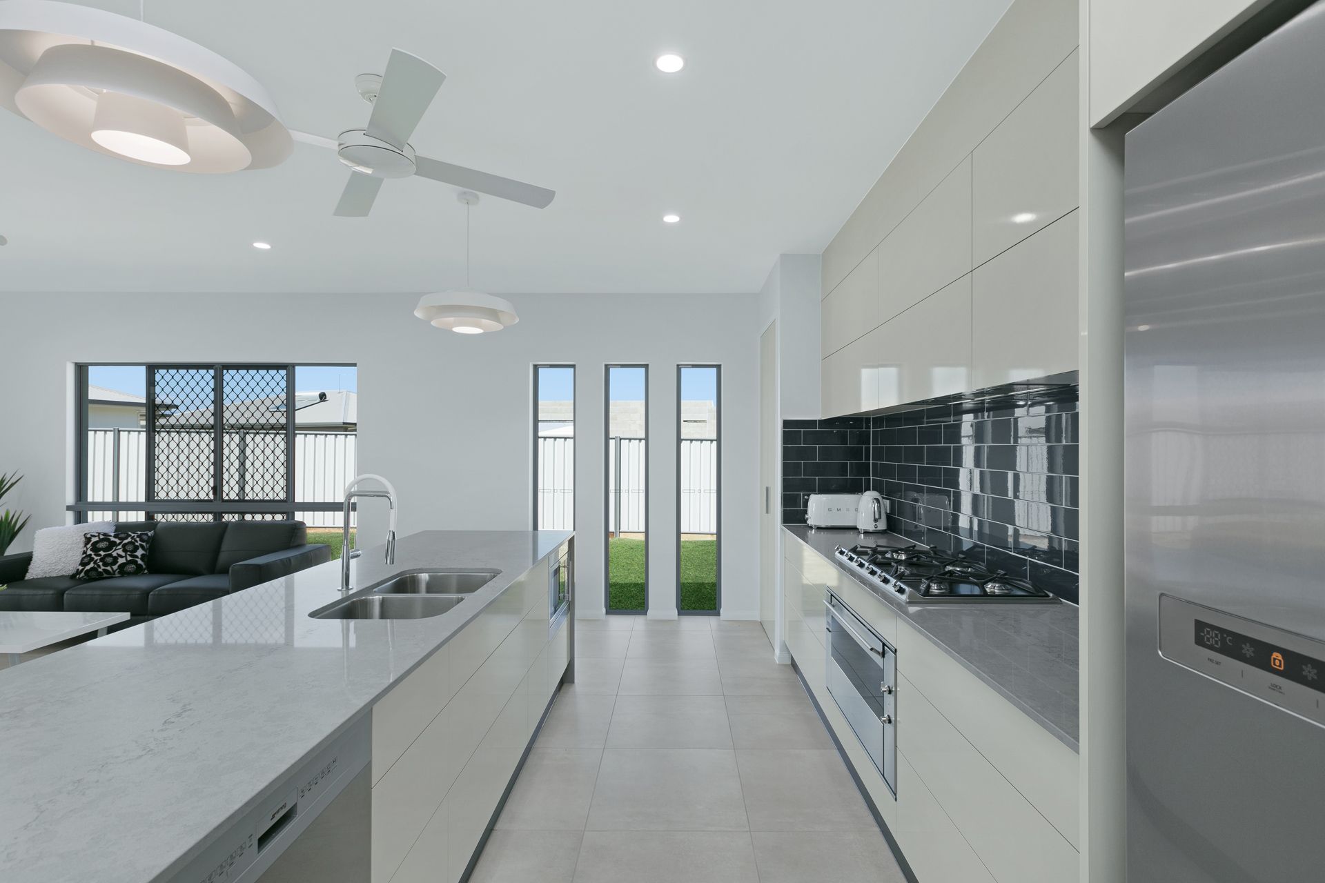 A Bright, Modern Kitchen With Light Cabinetry, Stone Countertops — Ashlee Jones Homes in Gordonvale, QLD
