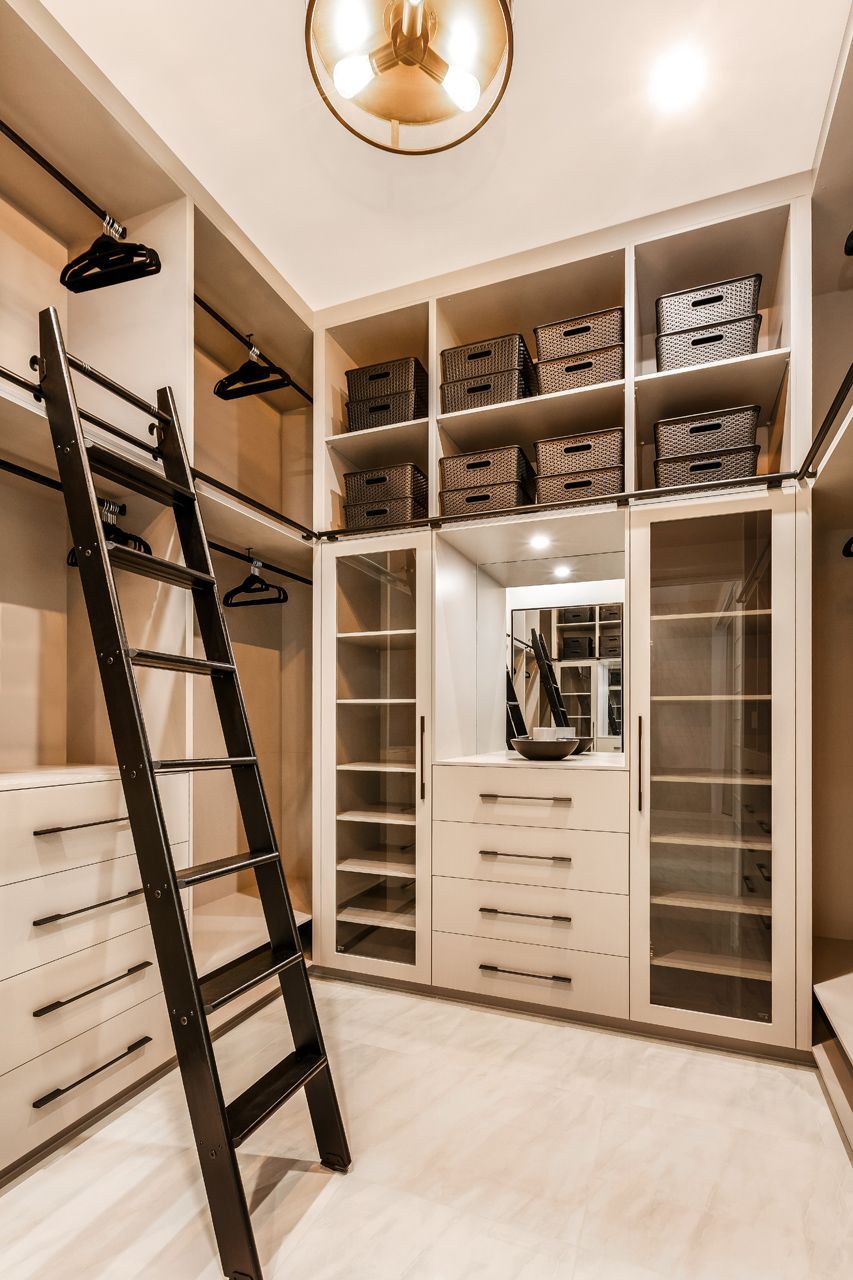 A Walk-in Closet Featuring Light-toned Cabinetry — Ashlee Jones Homes in Gordonvale, QLD