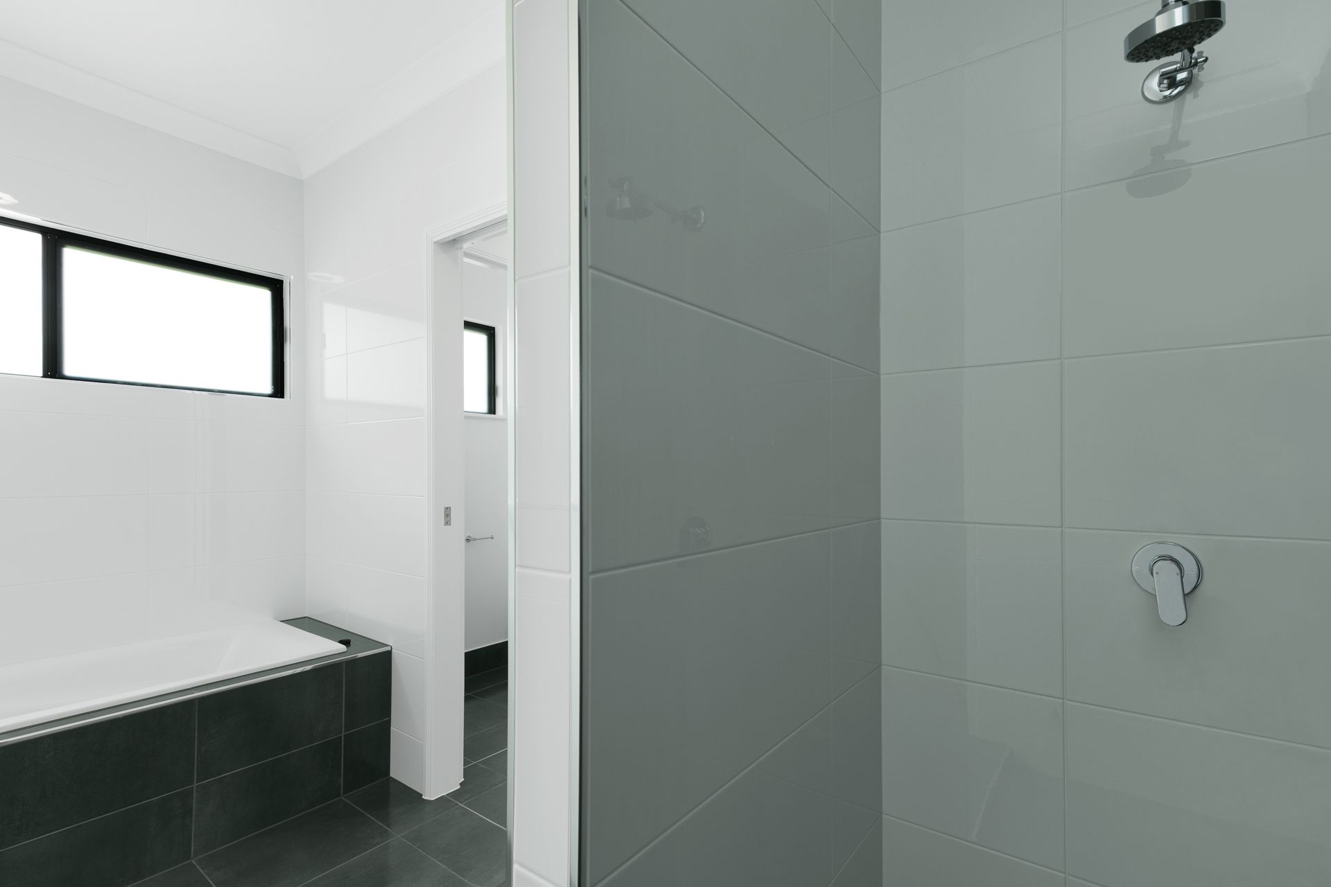 A Modern Bathroom Featuring a Dark-tiled Shower Area — Ashlee Jones Homes in Gordonvale, QLD