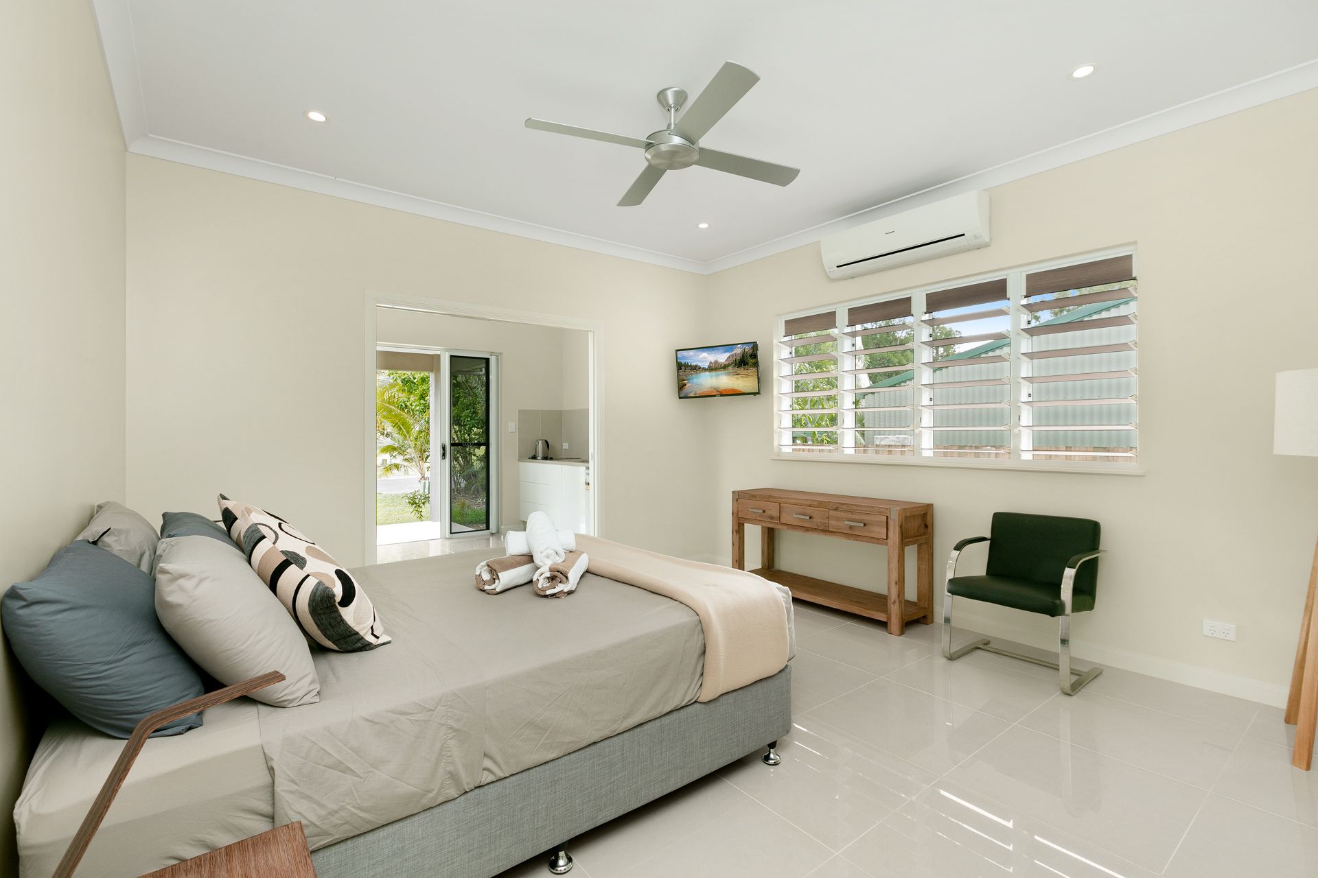 A Bright Hotel Bedroom Featuring a Bed With Gray Bedding — Ashlee Jones Homes in Gordonvale, QLD